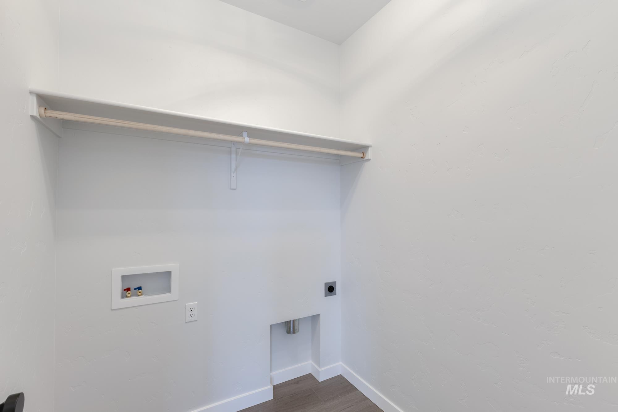 Washroom featuring wood finished floors, electric dryer hookup, and hookup for a washing machine