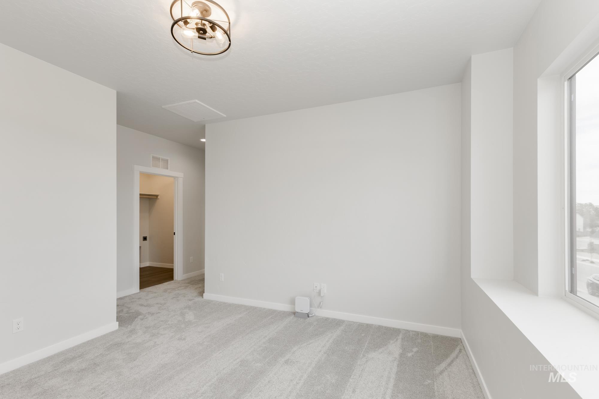 Spare room with light carpet and baseboards