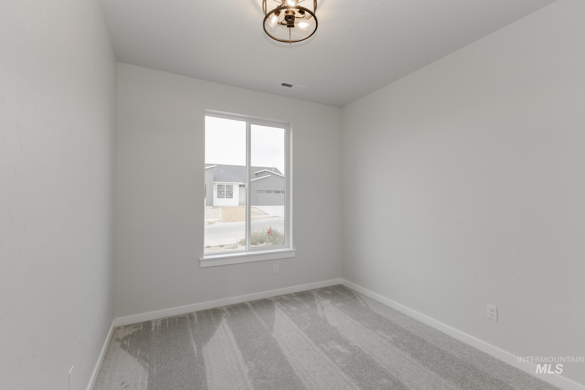 Carpeted spare room with baseboards