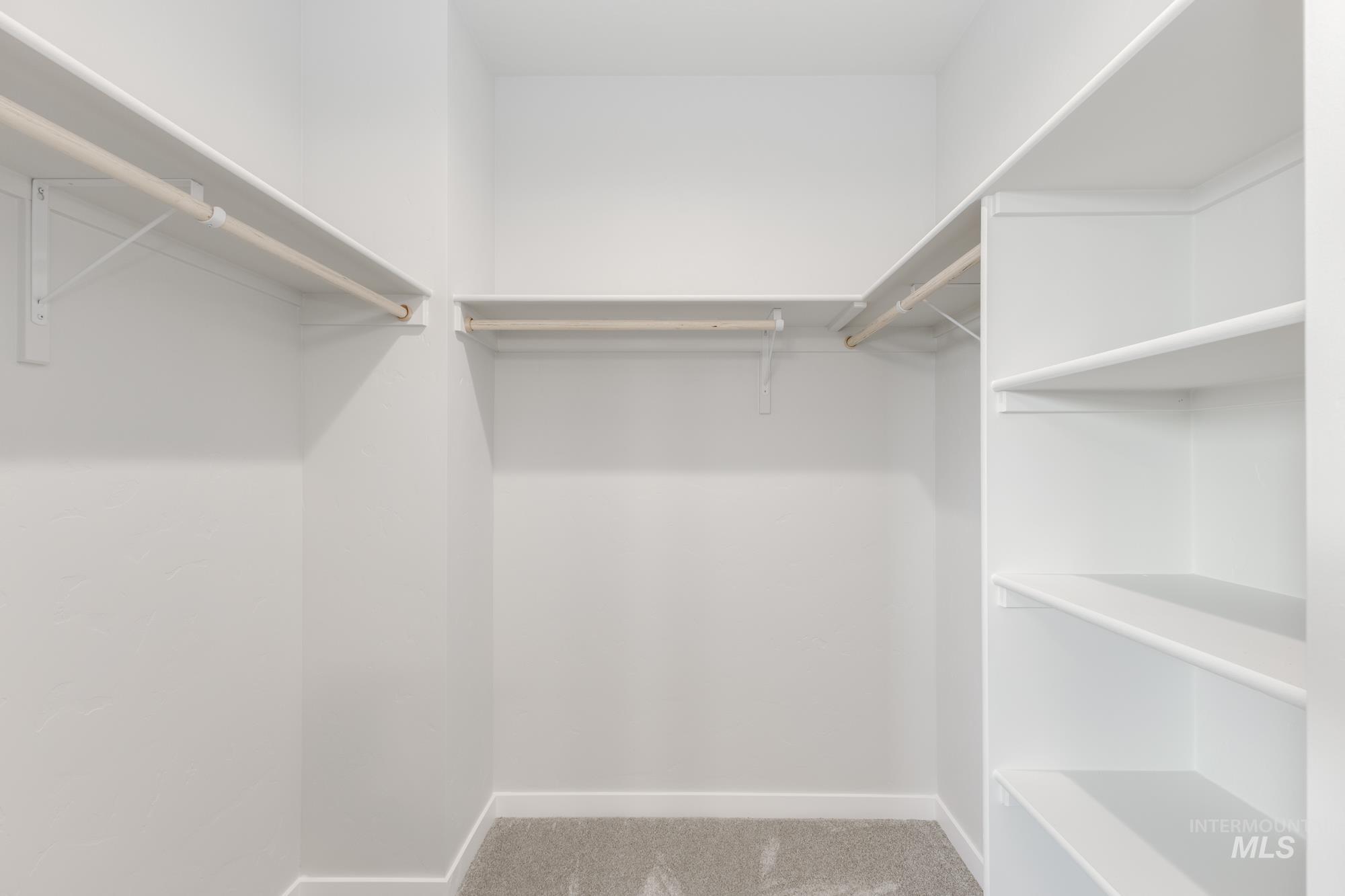 Spacious closet with light colored carpet