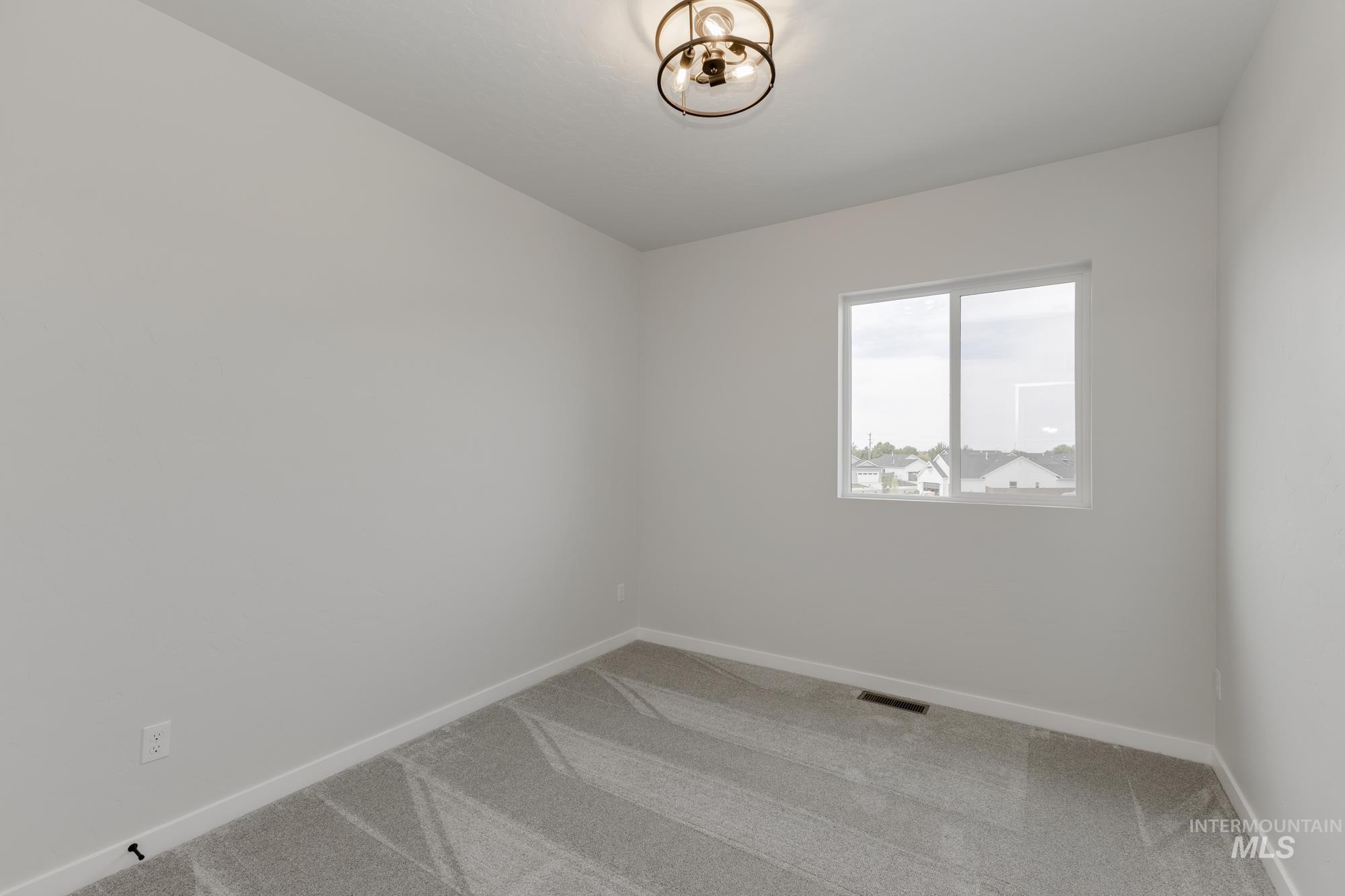 Empty room featuring light colored carpet and baseboards