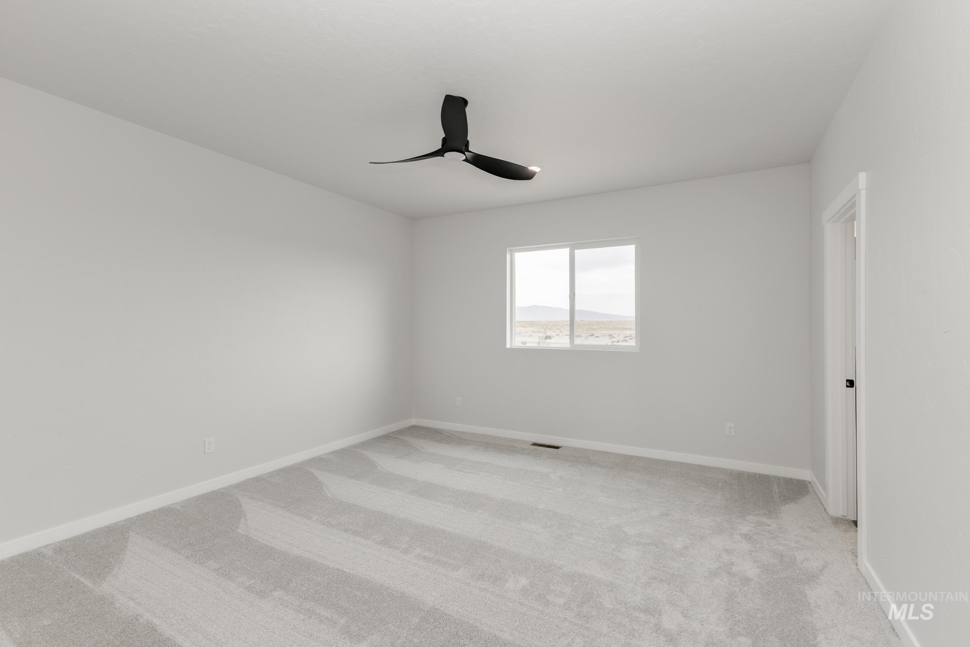 Unfurnished room featuring light carpet and ceiling fan
