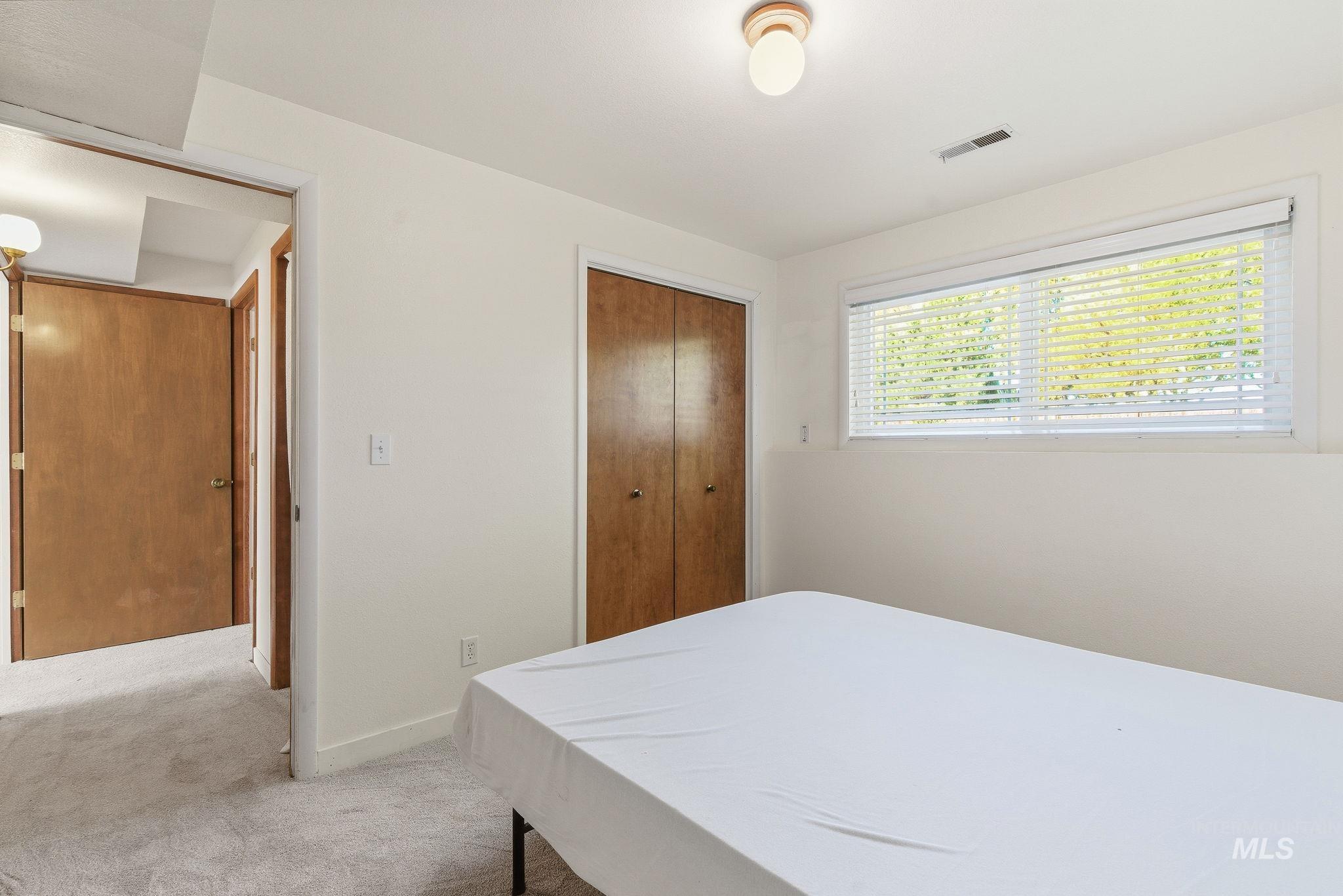 Carpeted bedroom featuring a closet and baseboards