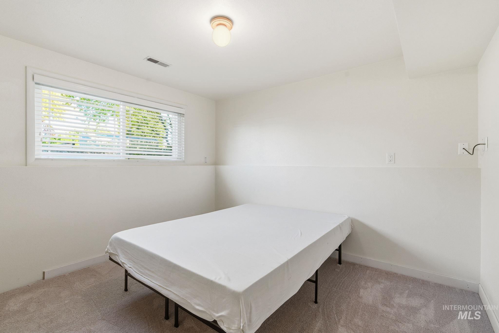 Bedroom with light carpet and baseboards