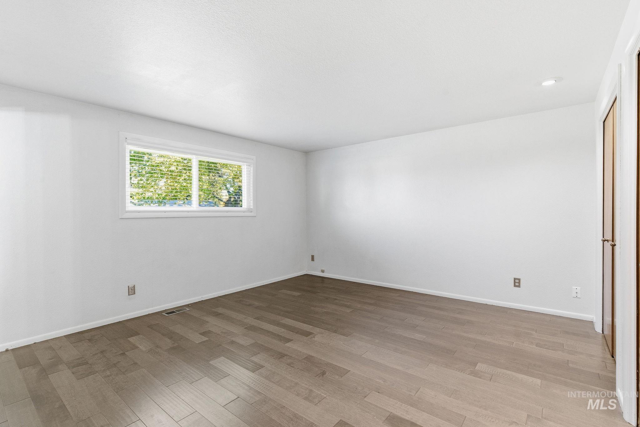 Empty room featuring light wood-style floors and recessed lighting