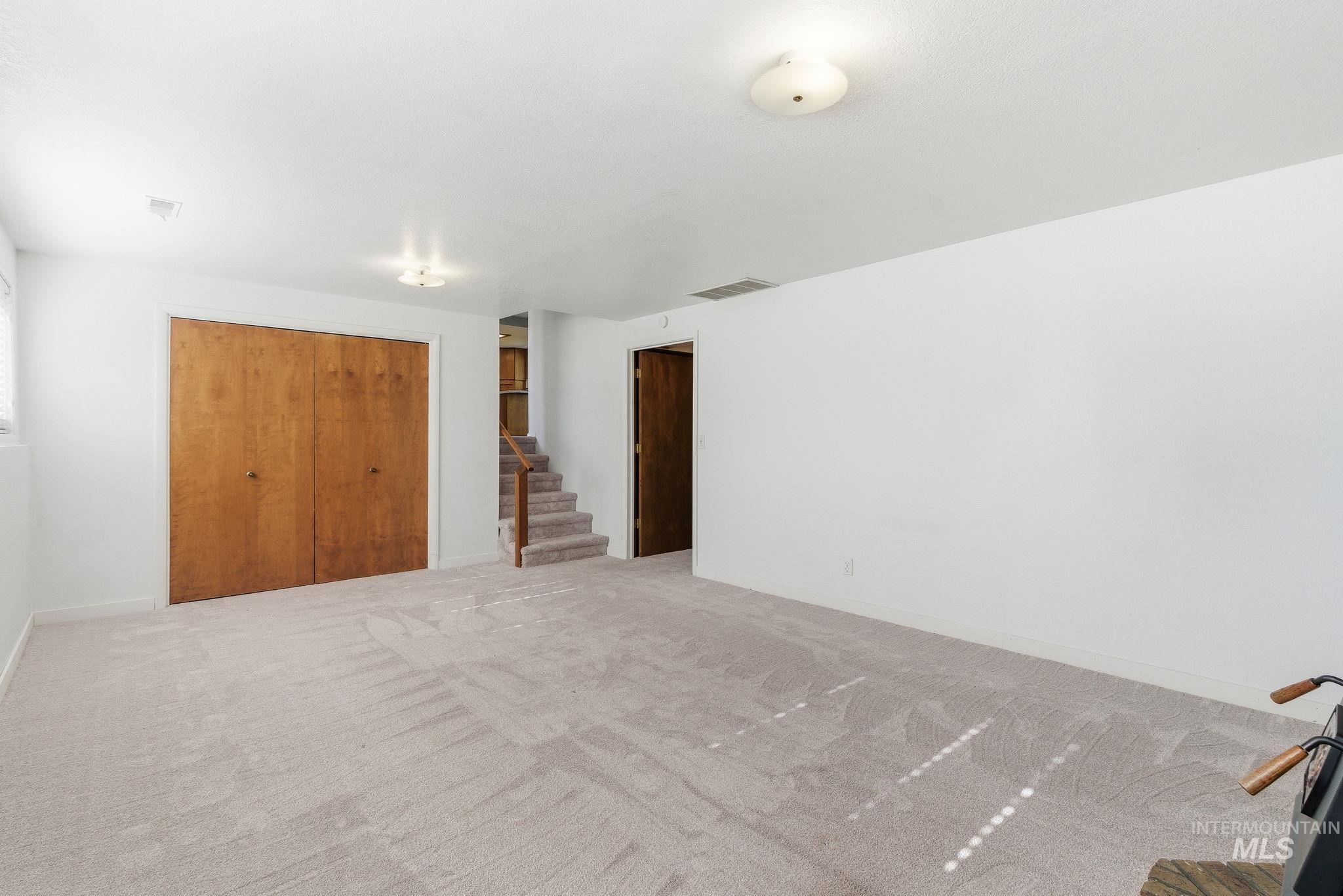 Empty room featuring carpet floors and stairs