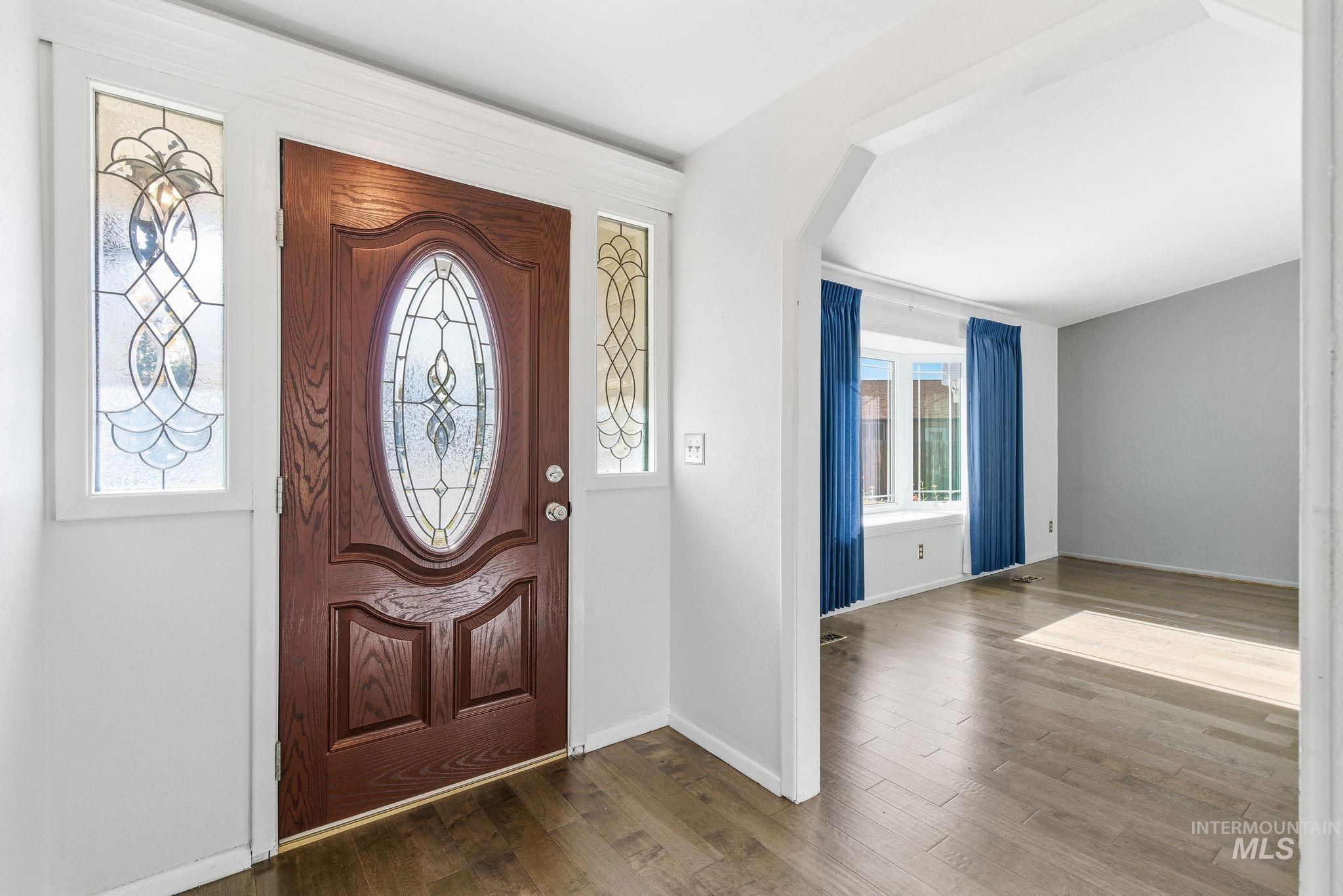 Entryway featuring wood finished floors and arched walkways