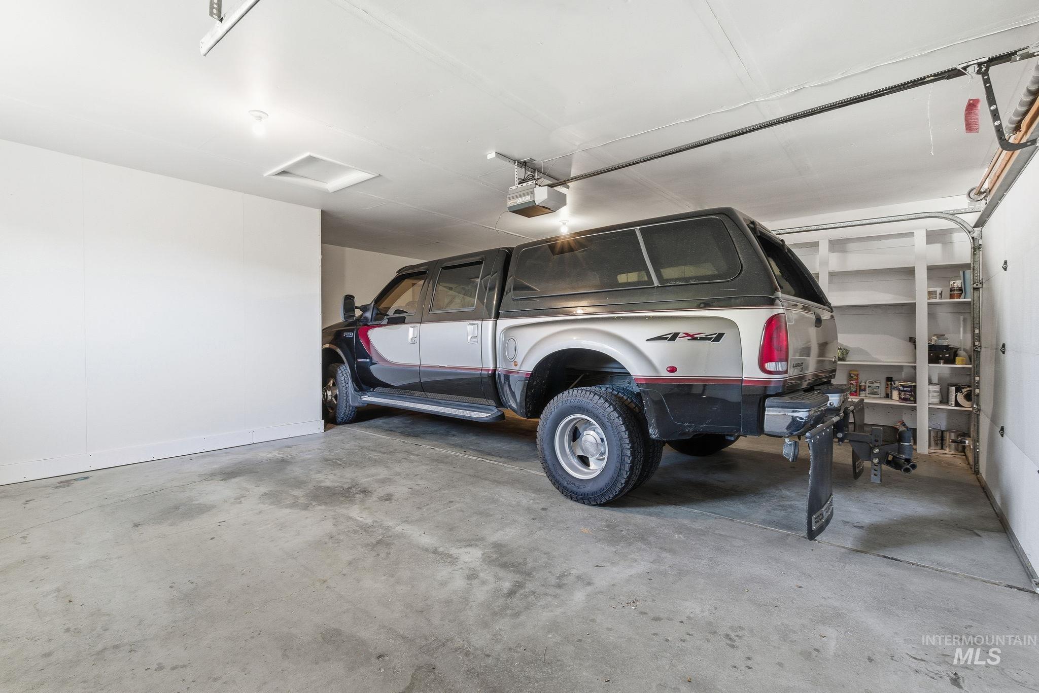 Garage featuring baseboards and a garage door opener