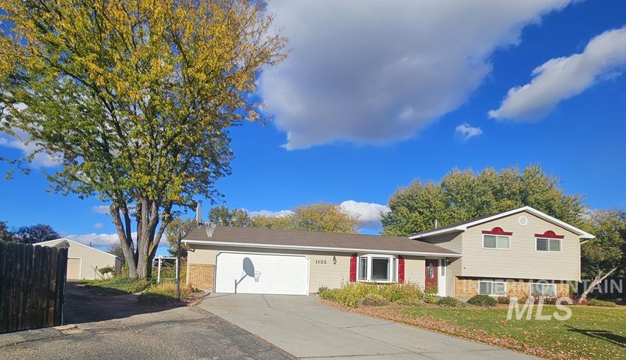 Split level home featuring brick siding, concrete driveway, and a garage