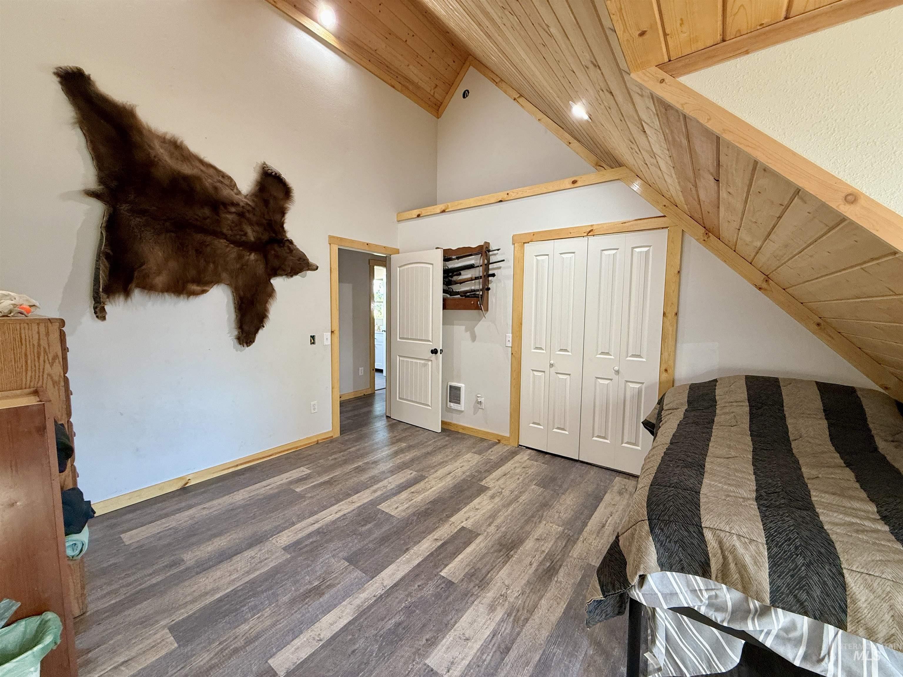 Bedroom with wooden ceiling, wood finished floors, a closet, recessed lighting, and high vaulted ceiling