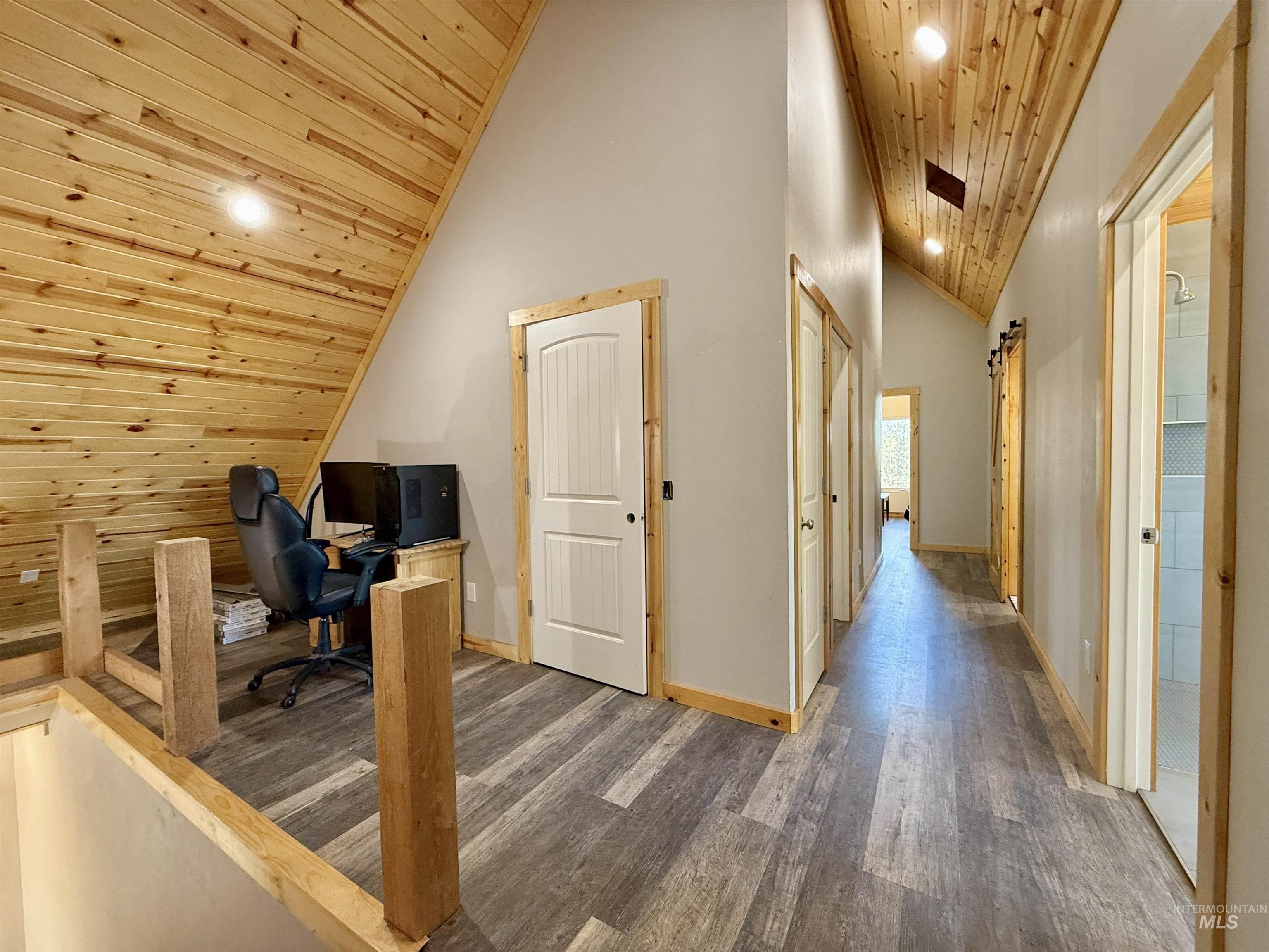 Office space featuring wooden ceiling, a barn door, wood finished floors, high vaulted ceiling, and recessed lighting