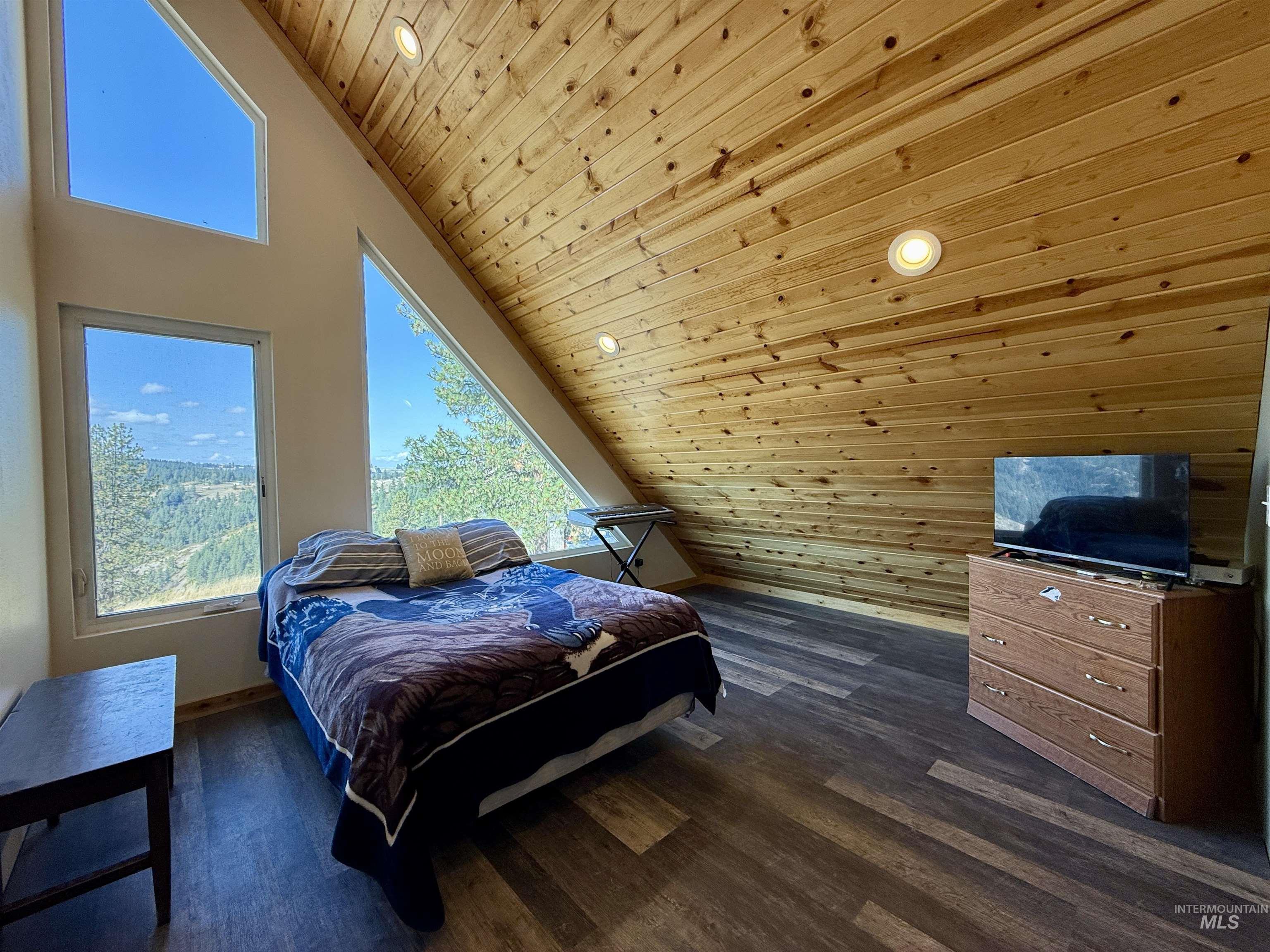 Bedroom with wooden ceiling, dark wood-type flooring, high vaulted ceiling, and recessed lighting