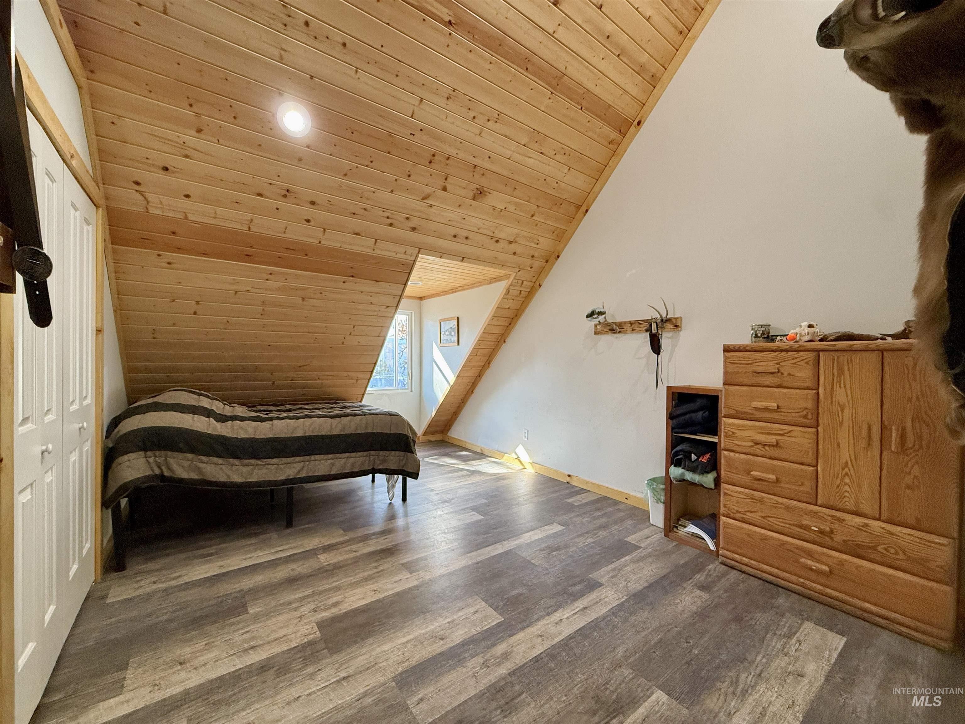 Bedroom with wood ceiling, vaulted ceiling, wood finished floors, a closet, and recessed lighting