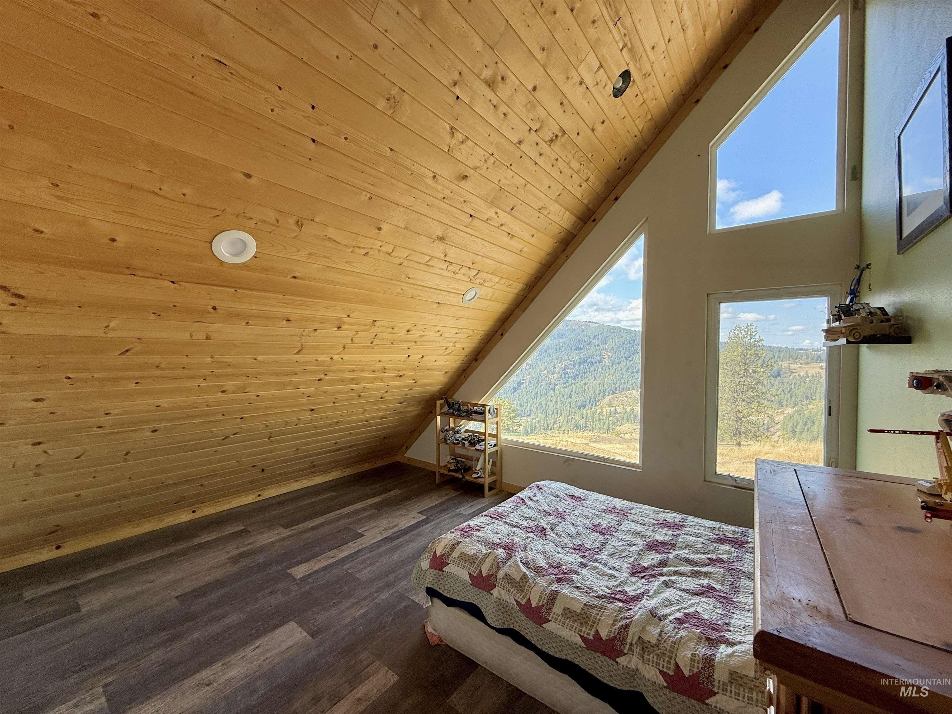 Bedroom with lofted ceiling, wooden ceiling, and dark wood finished floors