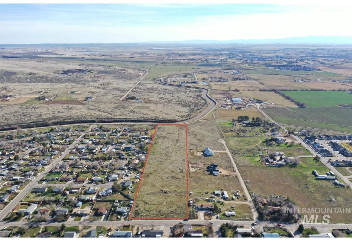 Aerial view of sparsely populated area featuring property boundaries highlighted and farmland