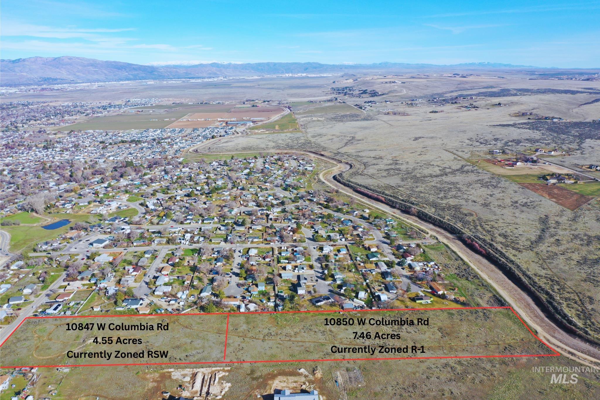 Aerial view of residential area featuring property boundaries highlighted and mountains