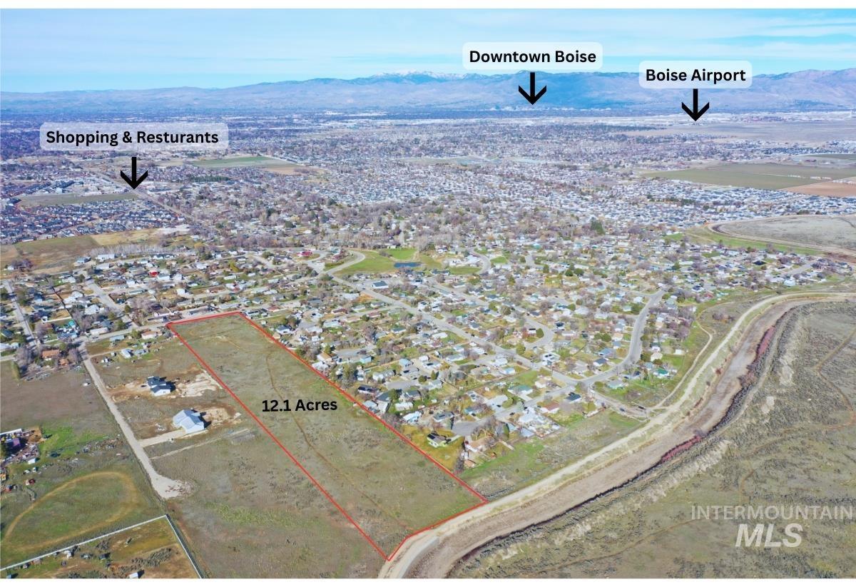 Aerial perspective of suburban area featuring property boundaries highlighted and a mountainous background