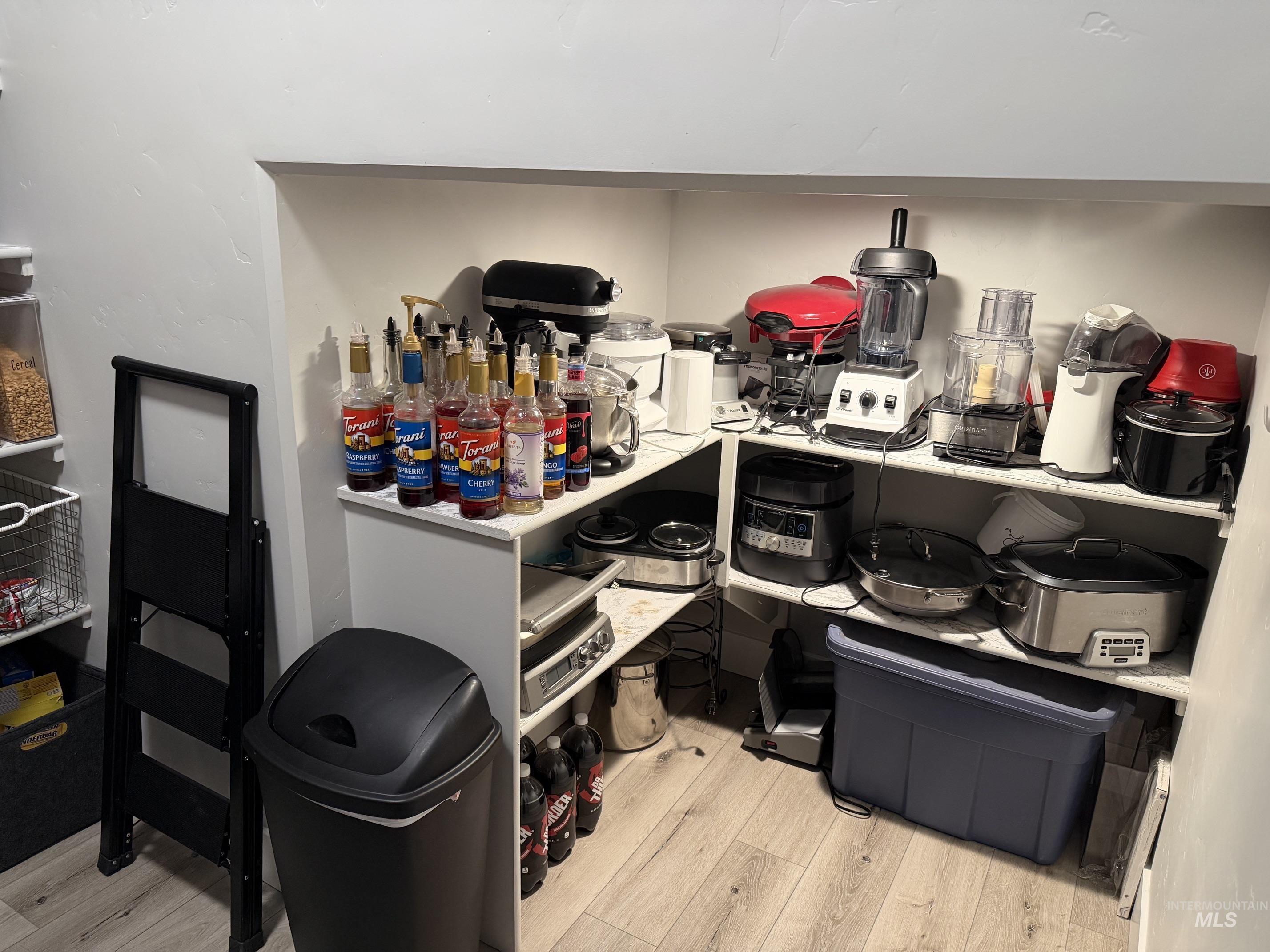 Built-in pantry shelving featuring light-toned wood-finish flooring