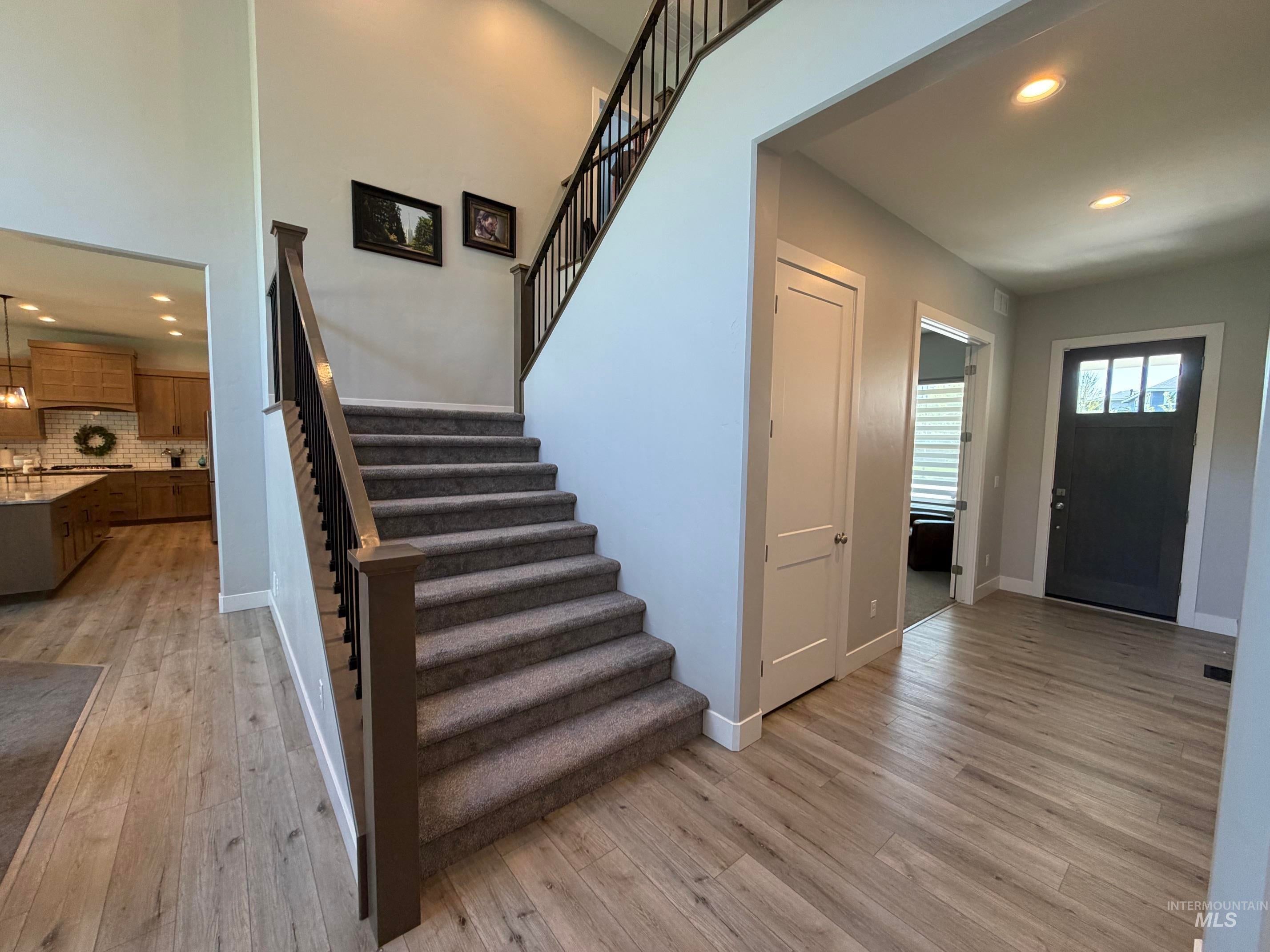 Carpeted staircase with dark wood-finish newel posts and metal balusters