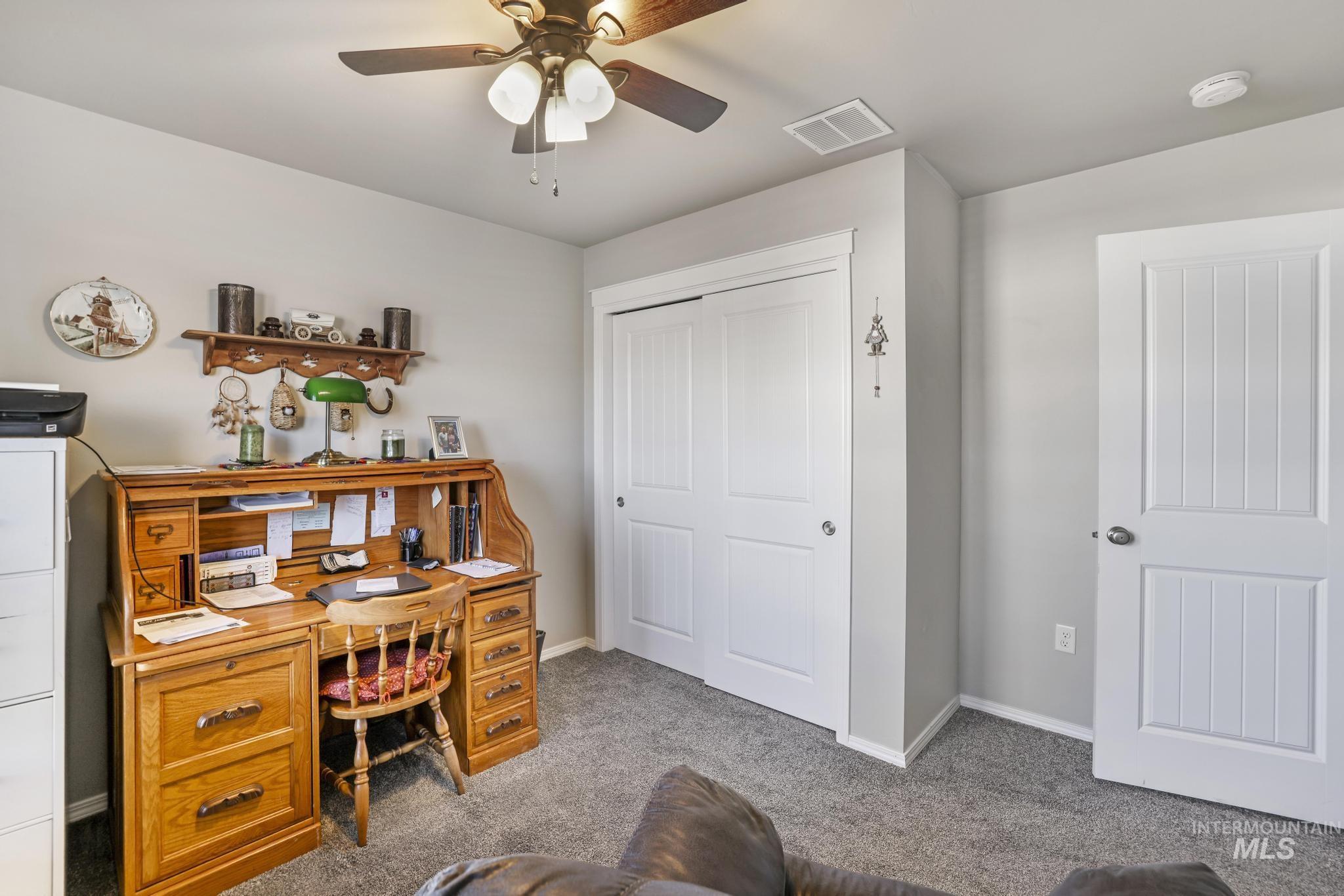 Home office with carpet floors and a ceiling fan