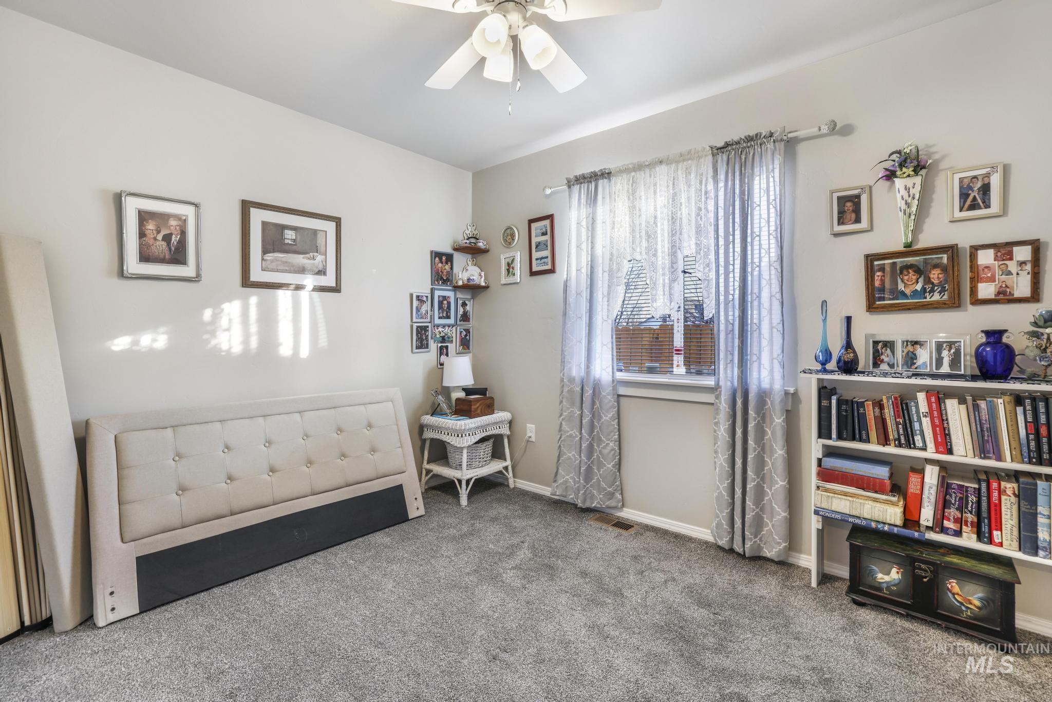 Living area featuring carpet floors and a ceiling fan