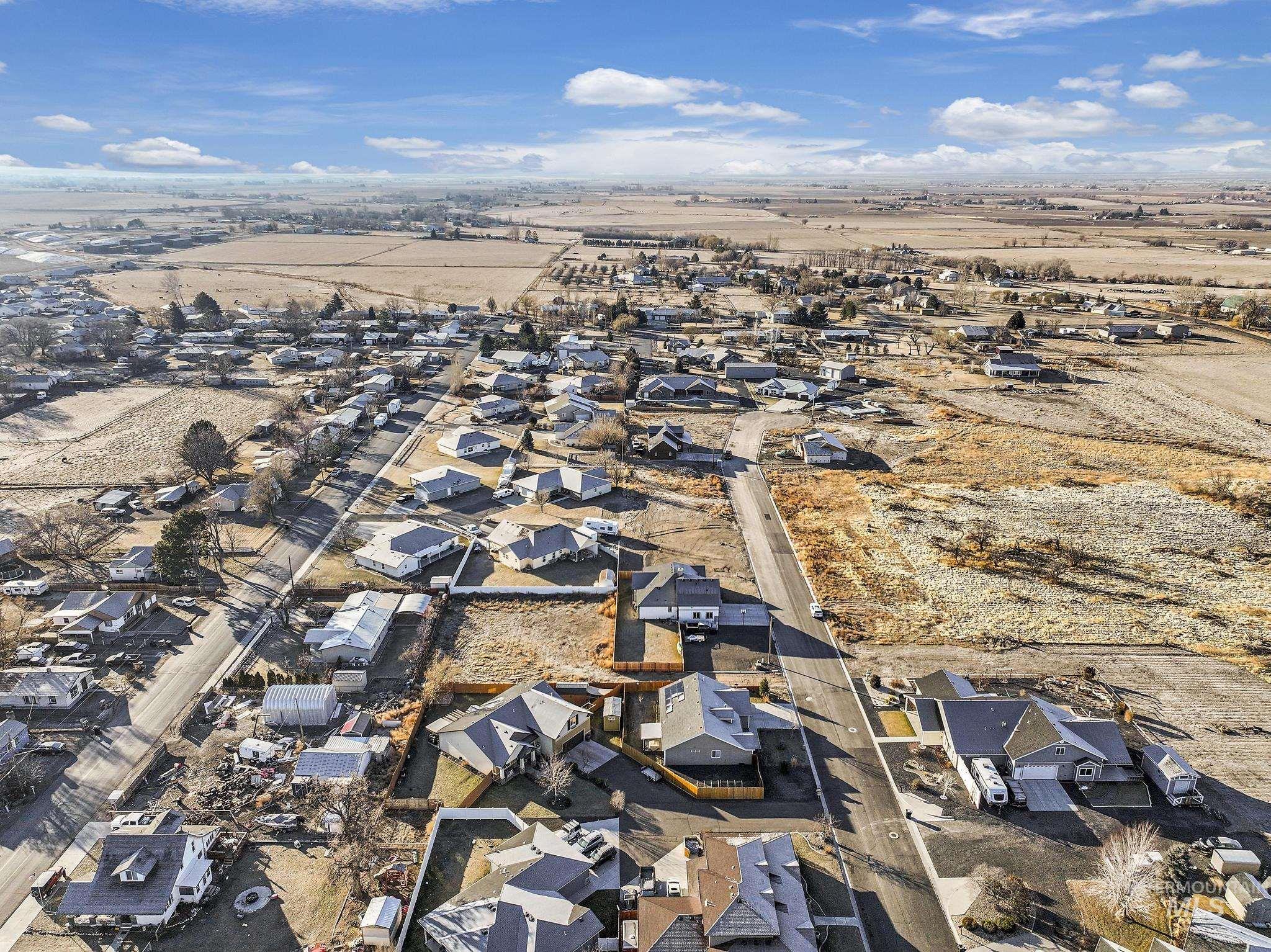 Aerial view of property and surrounding area featuring nearby suburban area