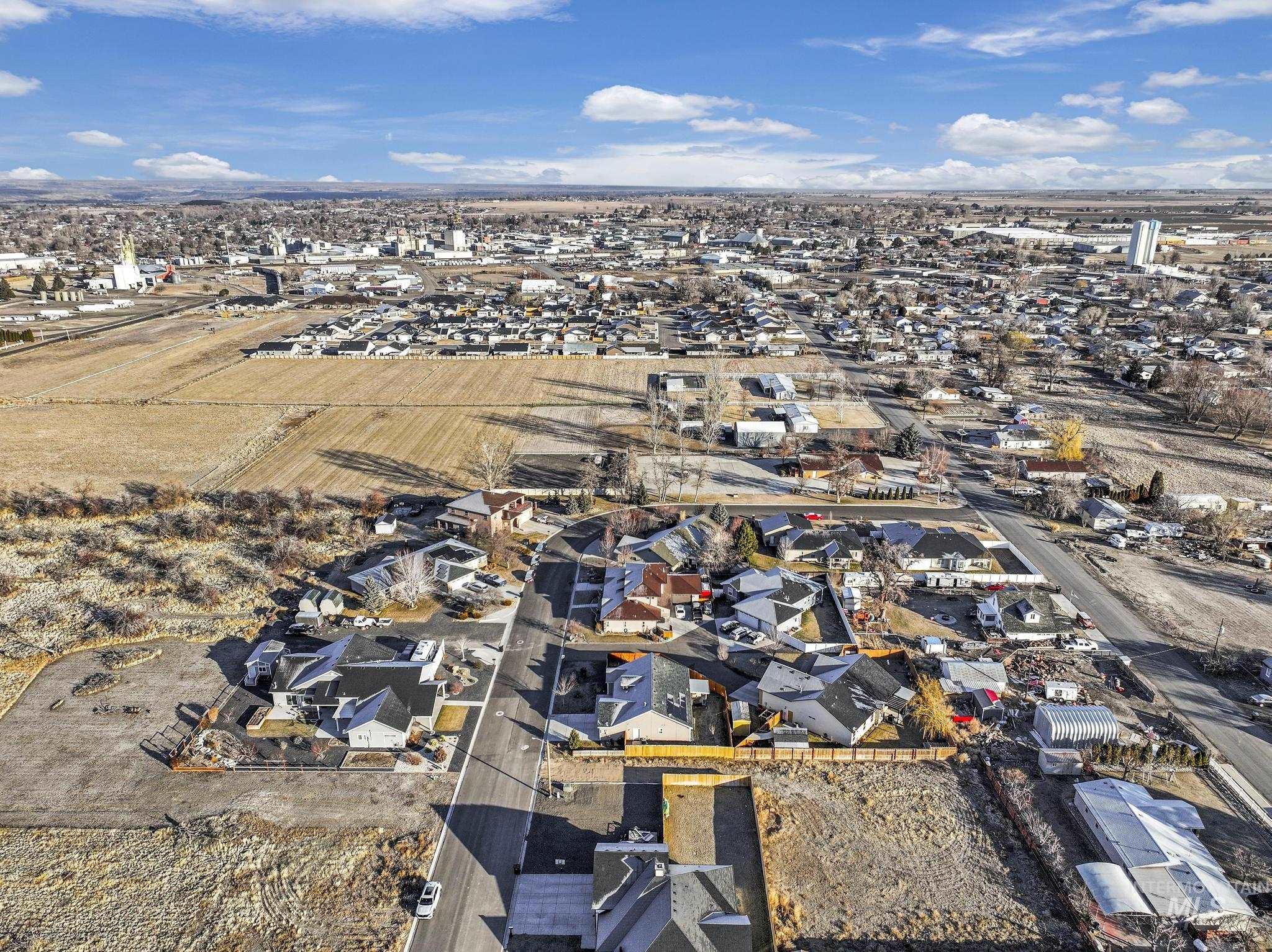 Aerial view of property and surrounding area featuring nearby suburban area