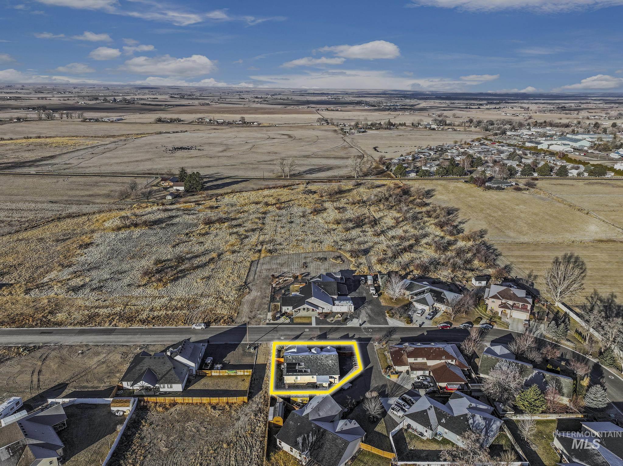 View of rural area with property parcel outlined and nearby suburban area