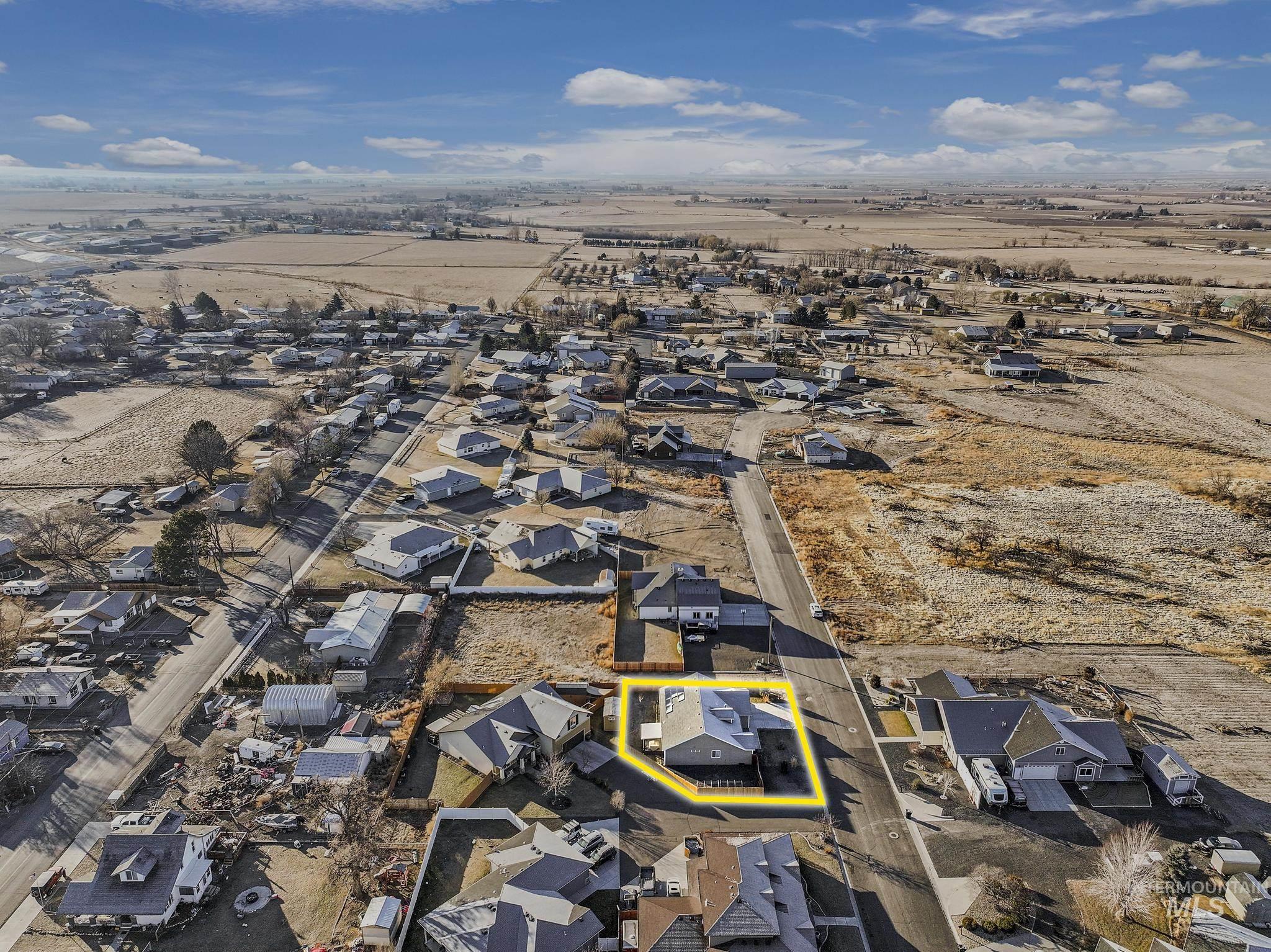 Aerial overview of property's location with nearby suburban area and property parcel outlined