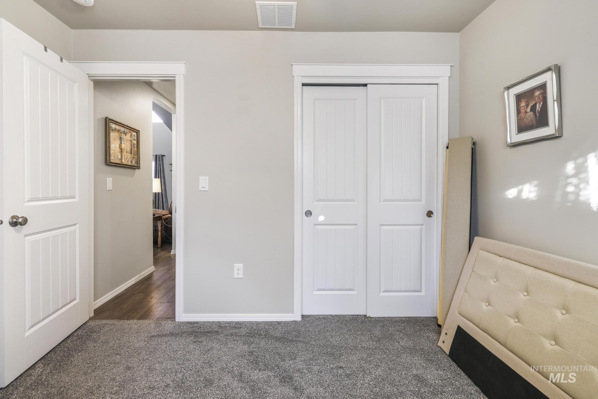 Bedroom featuring dark colored carpet and a closet