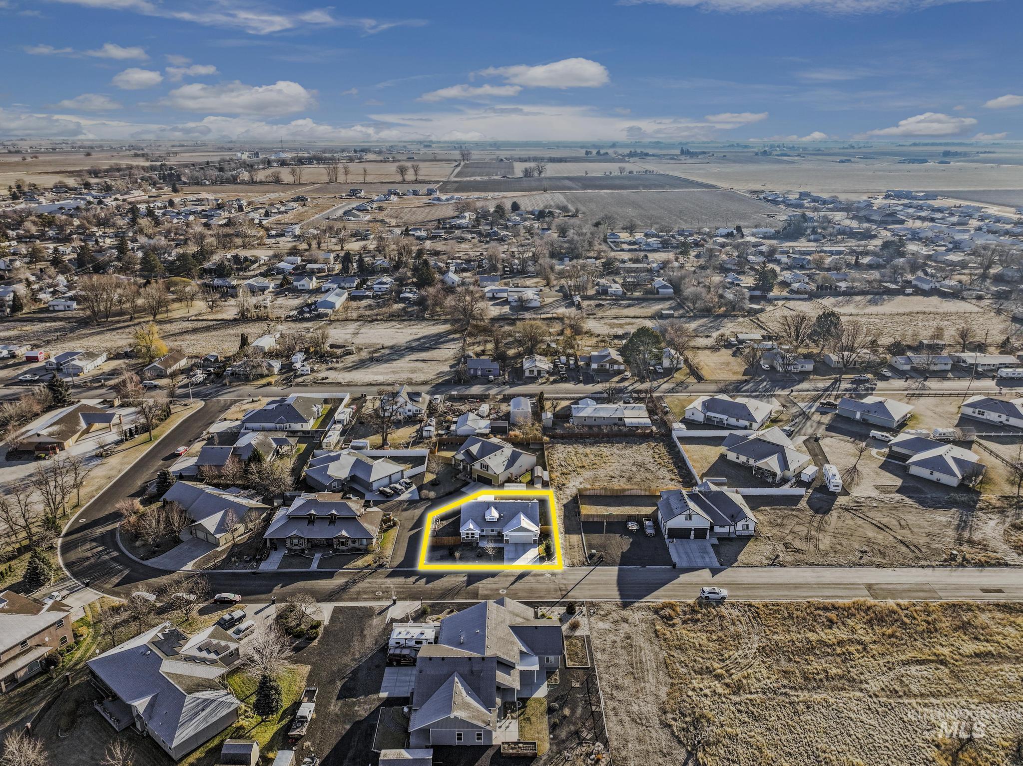 Aerial view of property and surrounding area with nearby suburban area and property parcel outlined