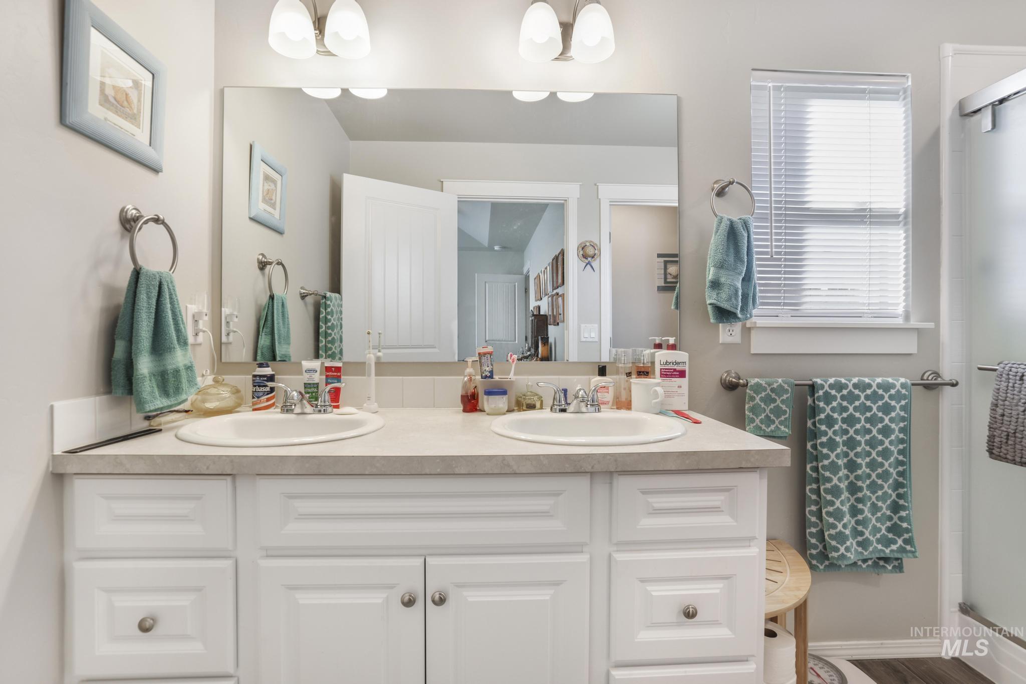 Full bath featuring double vanity and a shower stall