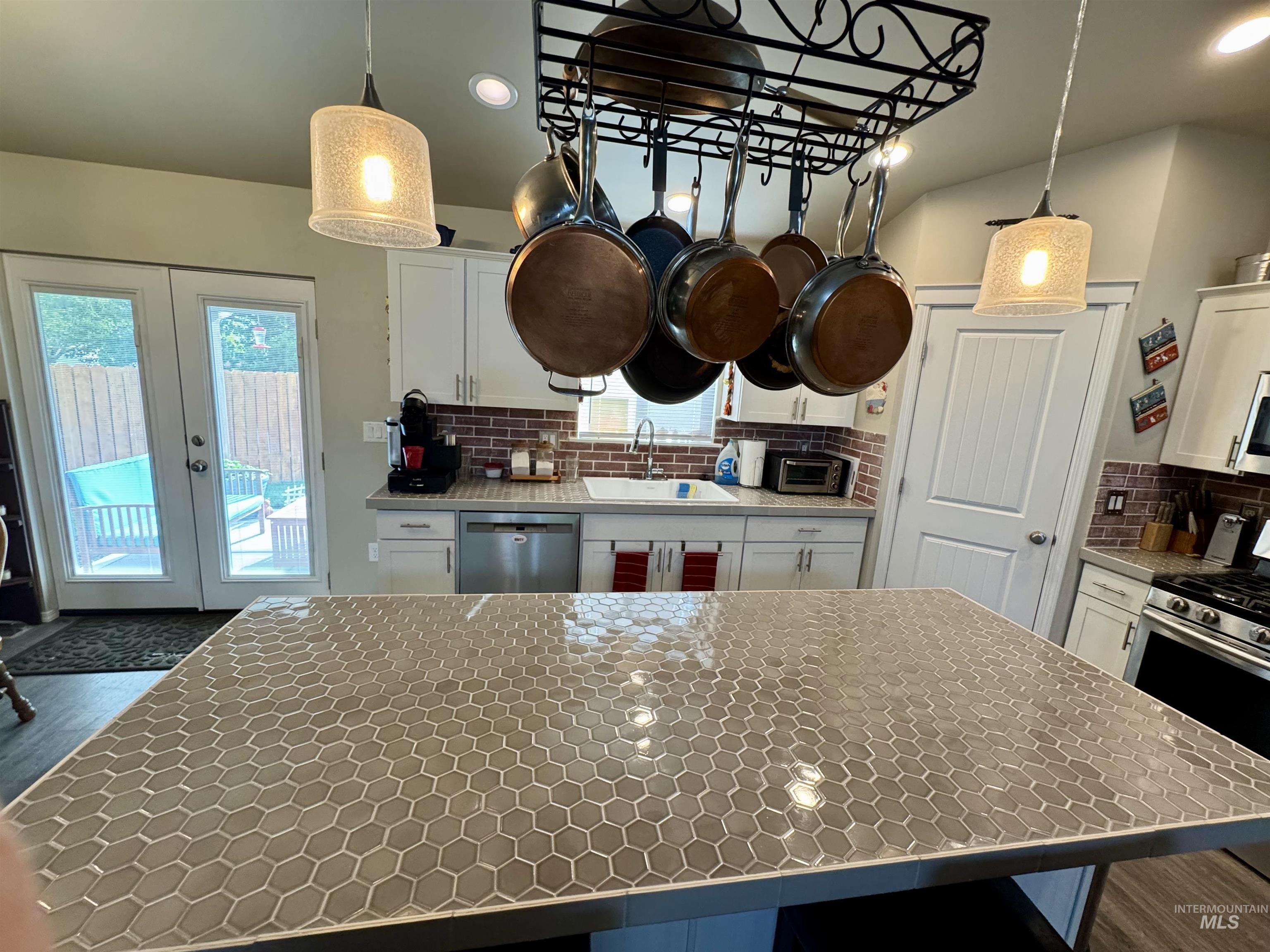 Kitchen featuring white cabinets, a breakfast bar area, recessed lighting, stainless steel appliances, and french doors
