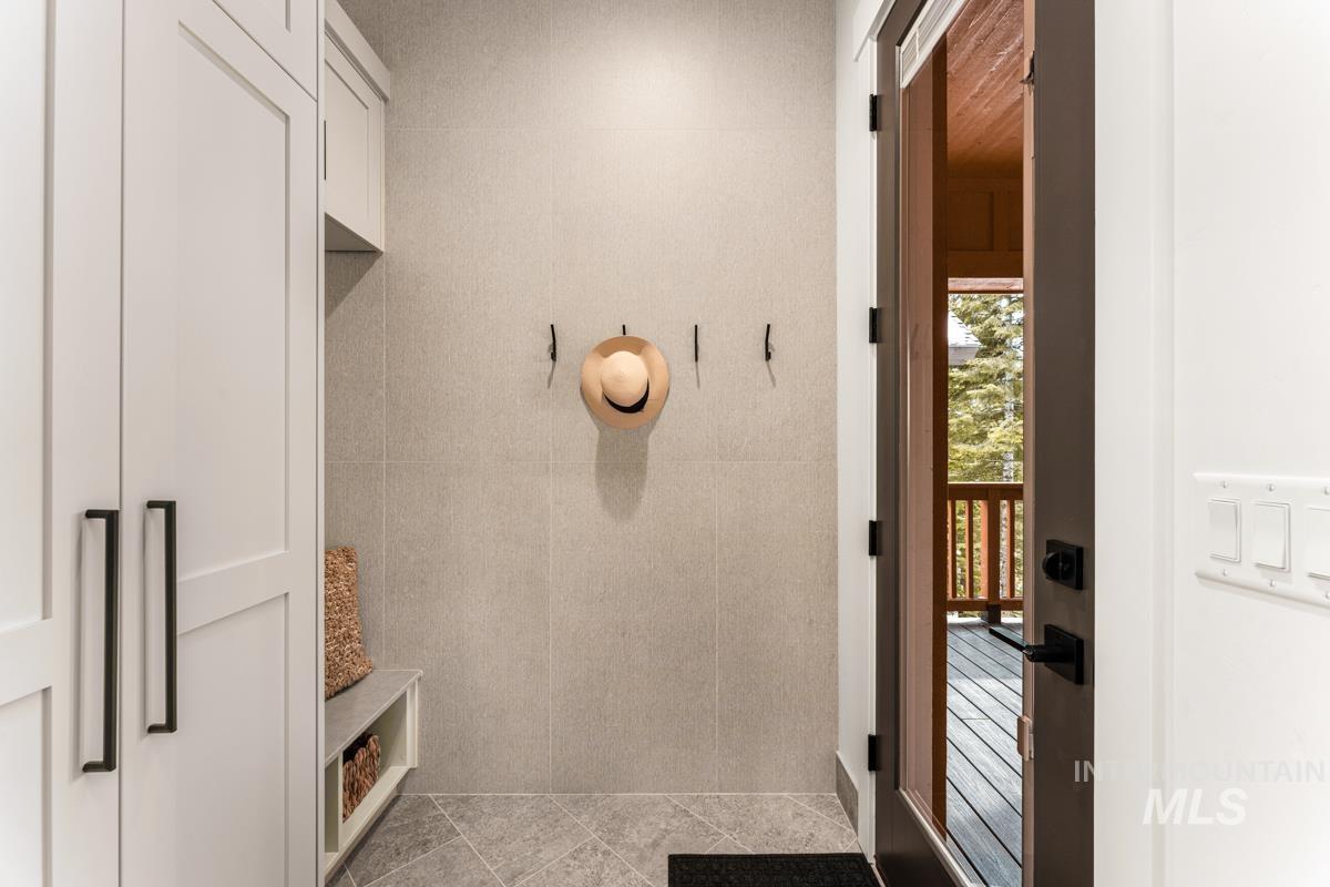 Mudroom featuring tile walls and light tile patterned floors
