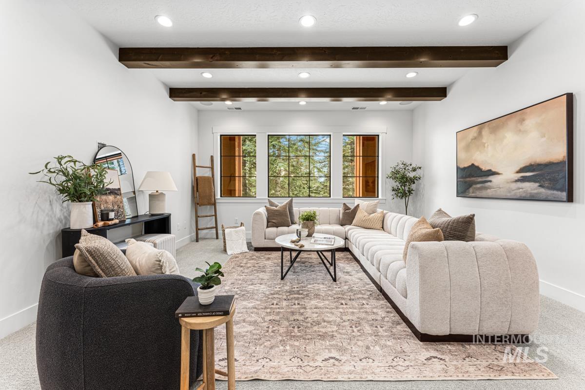 Living room with recessed lighting, beam ceiling, and light colored carpet