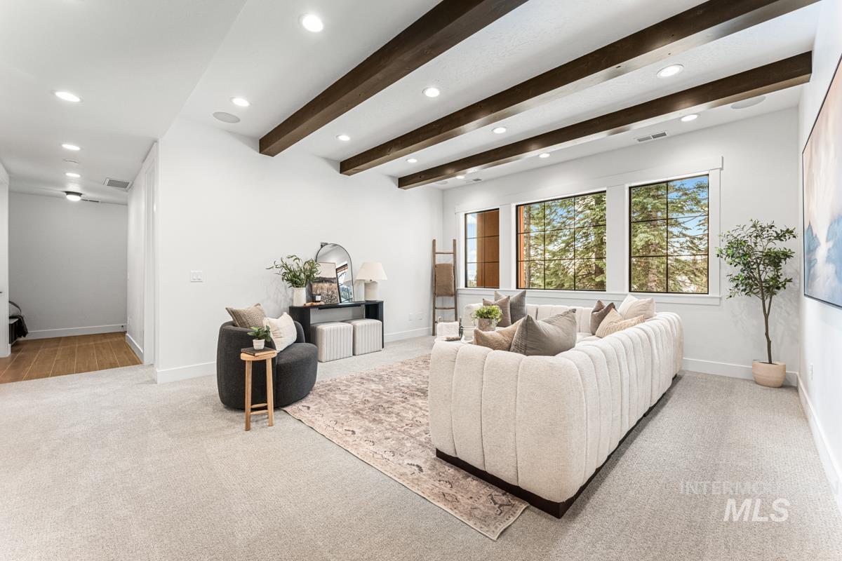 Living area with beamed ceiling, light carpet, and recessed lighting