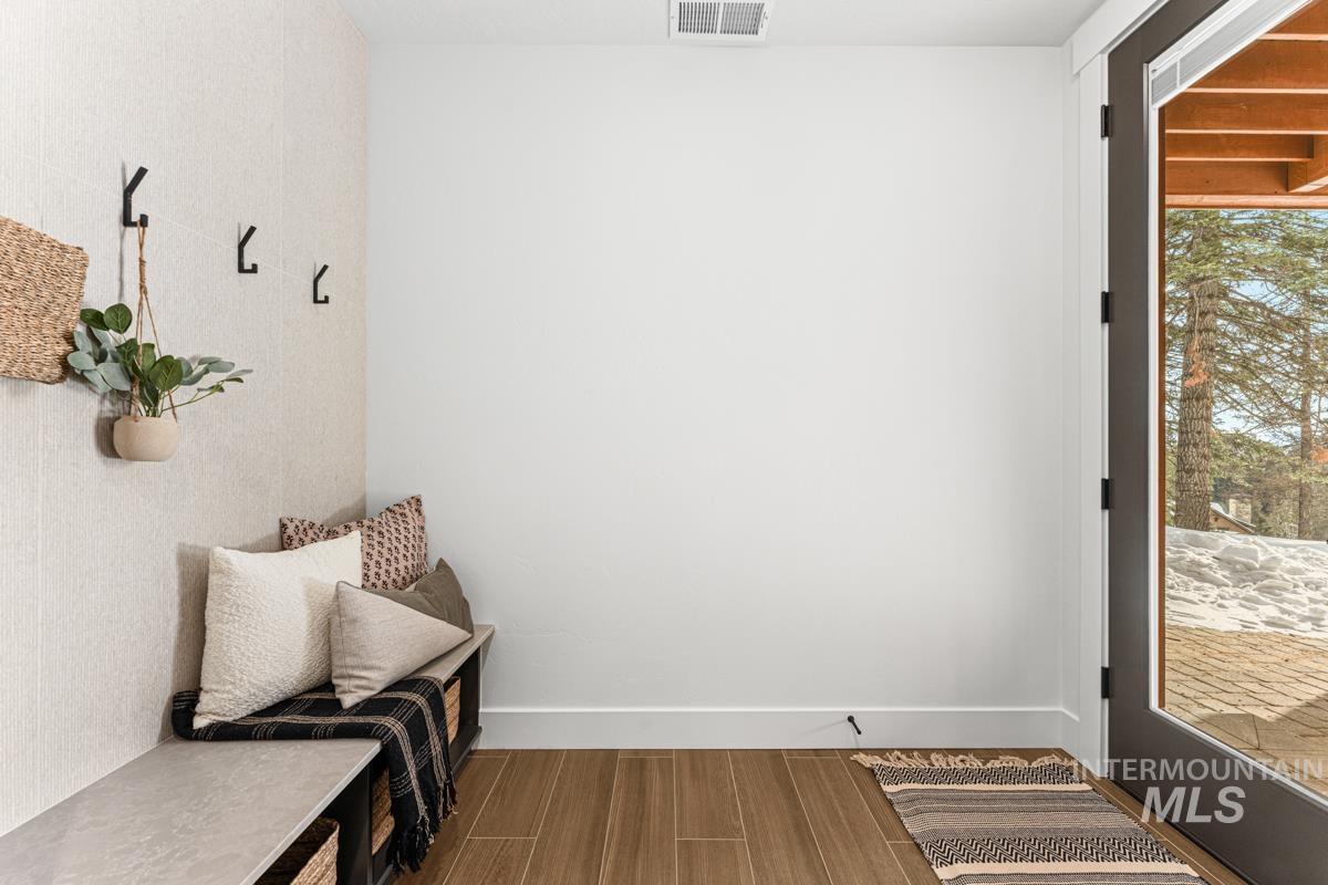 Mudroom with dark wood-style flooring and baseboards