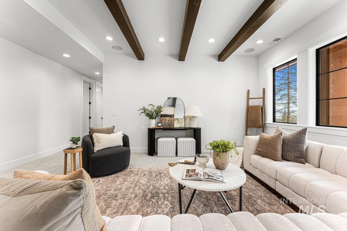 Carpeted living area featuring recessed lighting and beamed ceiling