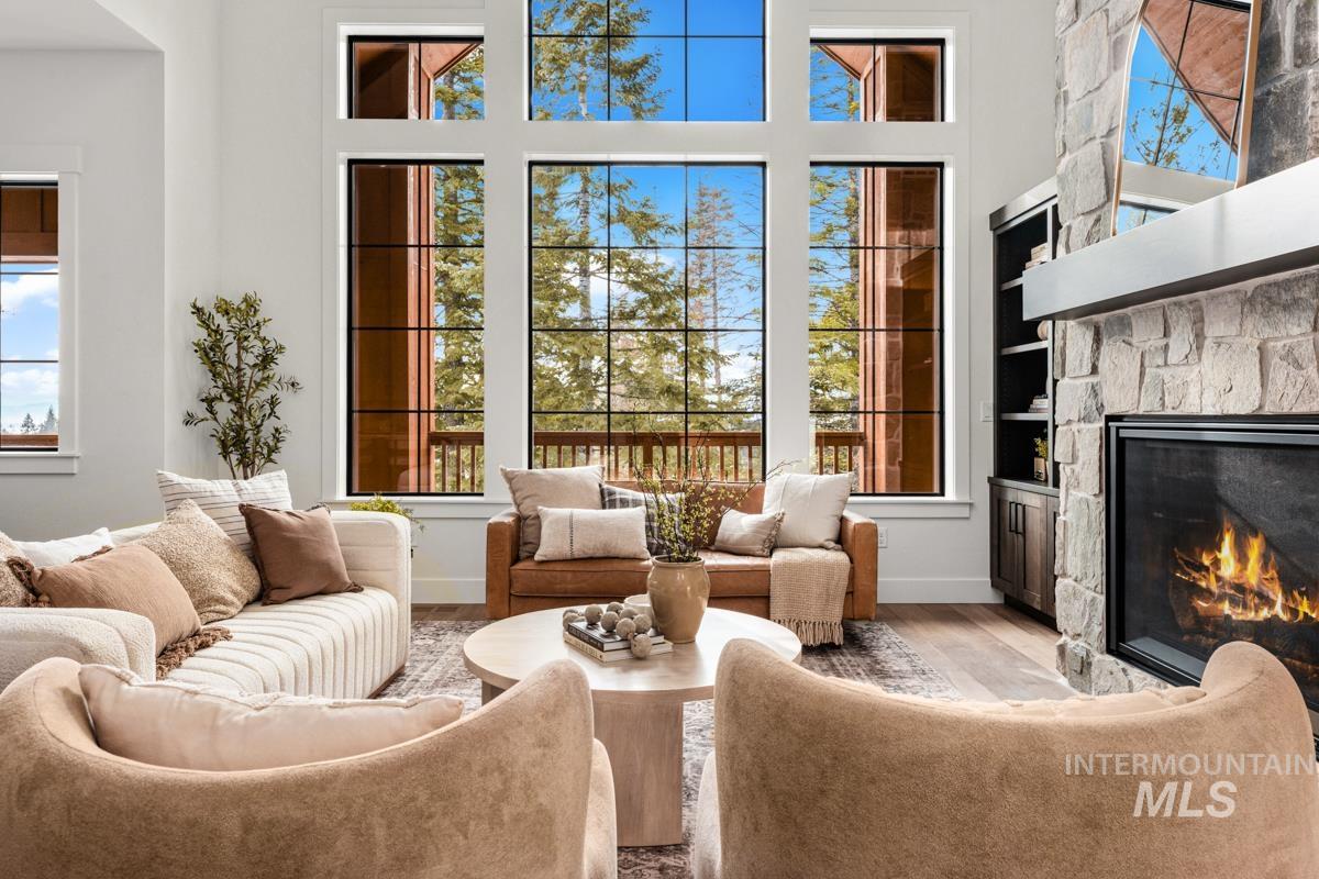 Living area featuring a fireplace, wood finished floors, a towering ceiling, and built in features