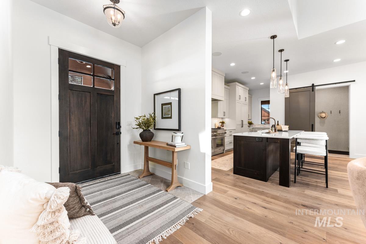 Foyer with a barn door, light wood-type flooring, and recessed lighting