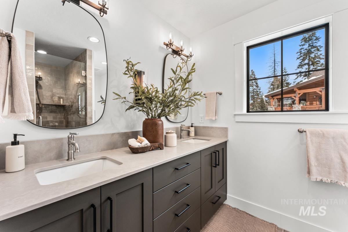 Full bathroom with double vanity and a shower stall