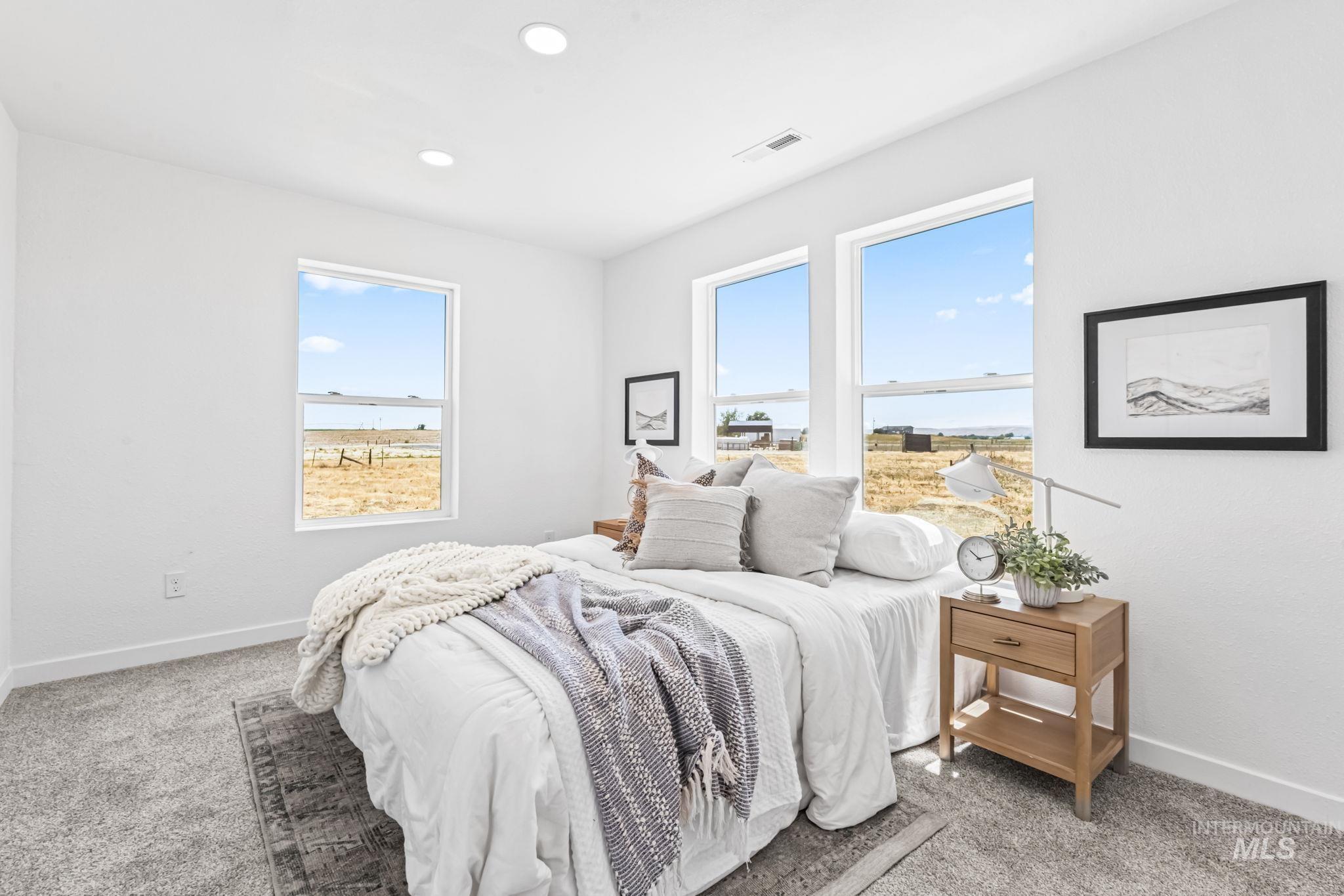 Carpeted bedroom with multiple windows and recessed lighting