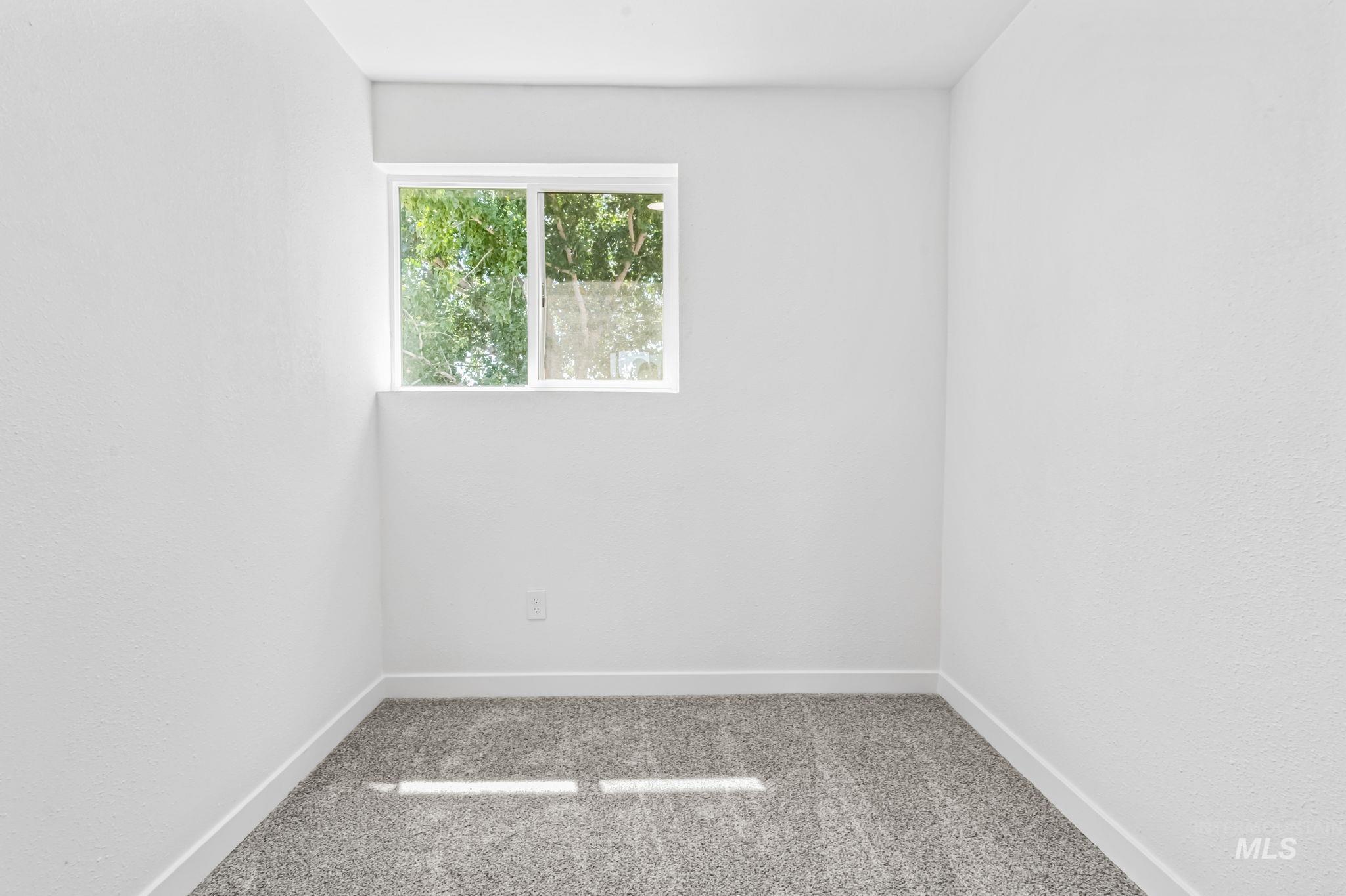 Carpeted empty room with baseboards