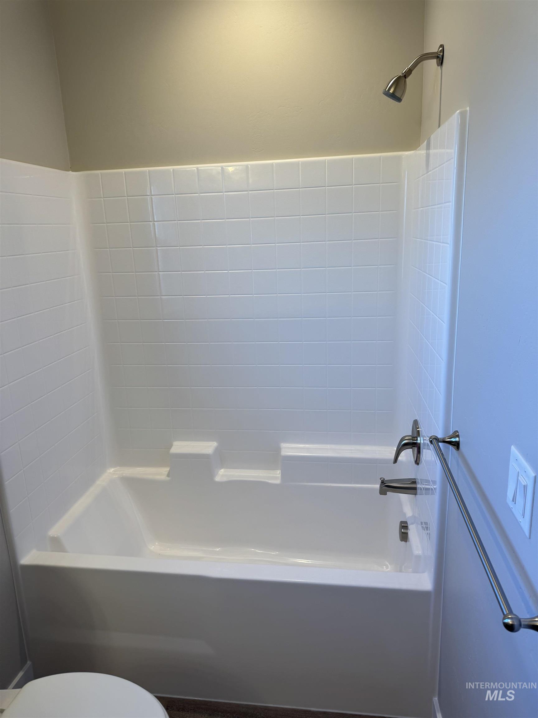 Bathroom featuring toilet and shower / washtub combination