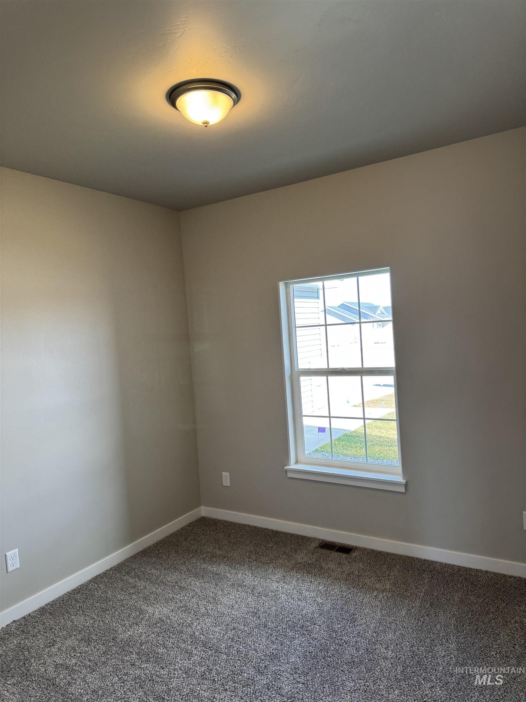 Carpeted empty room featuring baseboards