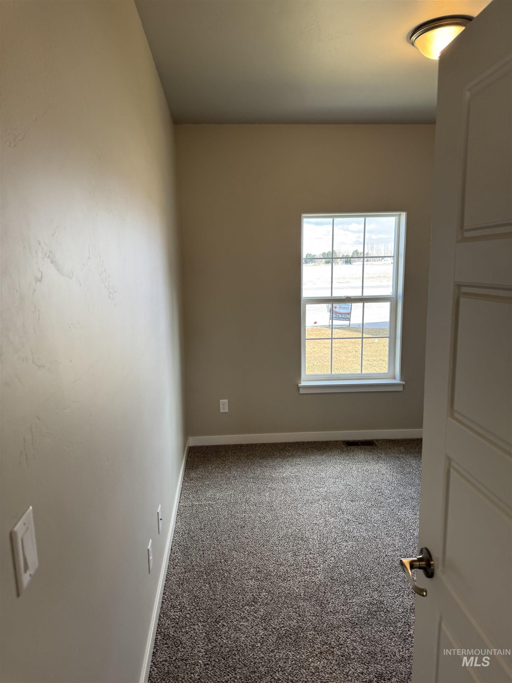 Carpeted spare room with baseboards