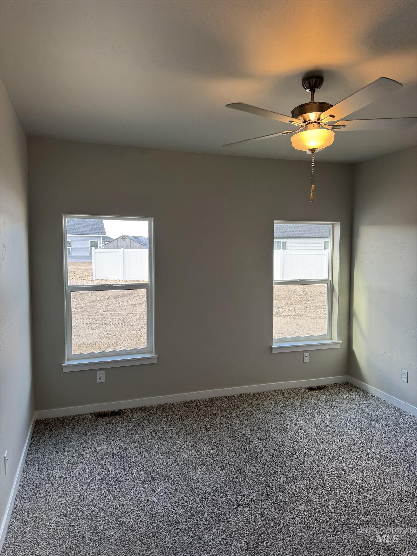 Unfurnished room featuring carpet floors and a ceiling fan