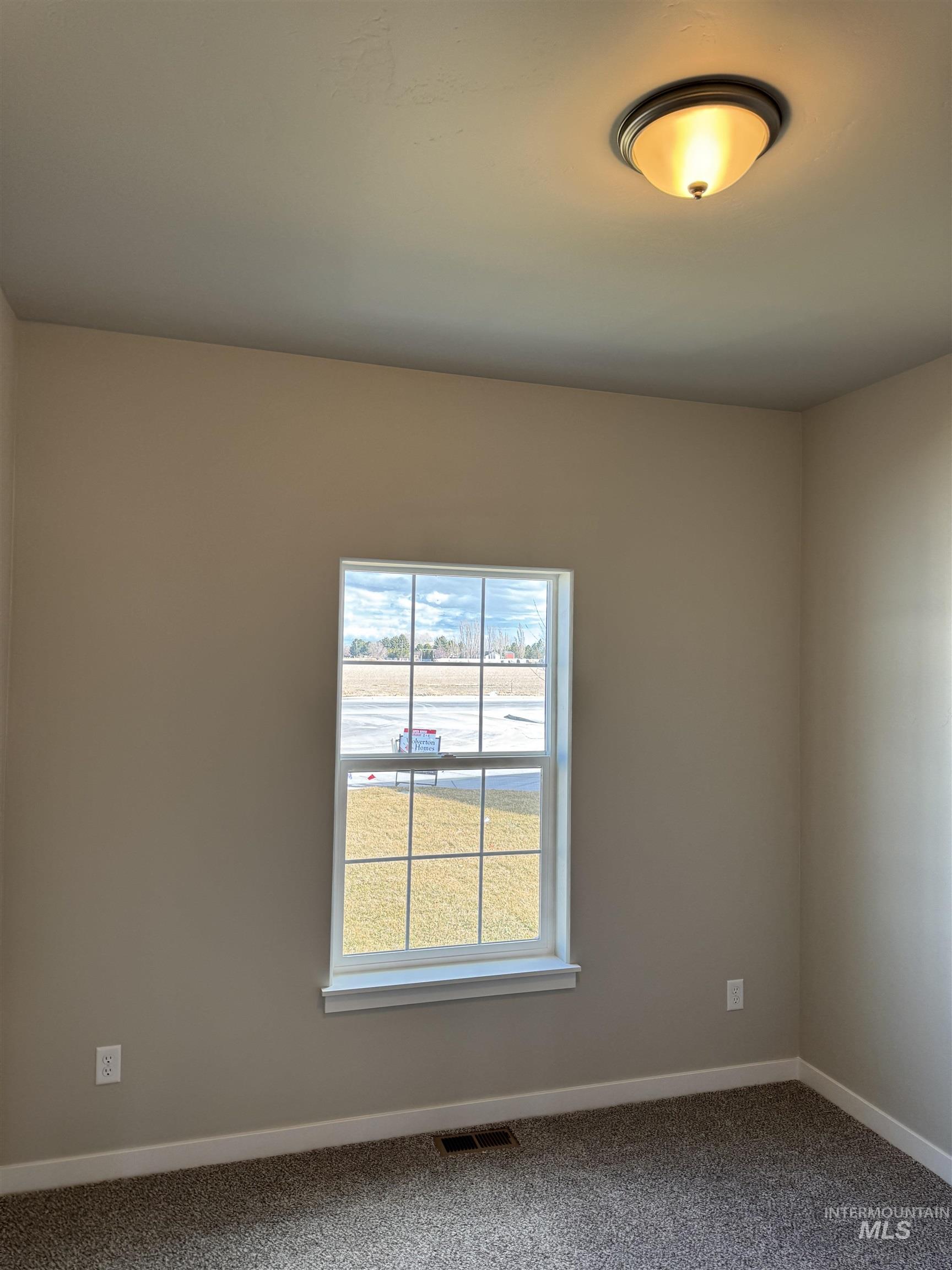 Carpeted empty room featuring baseboards
