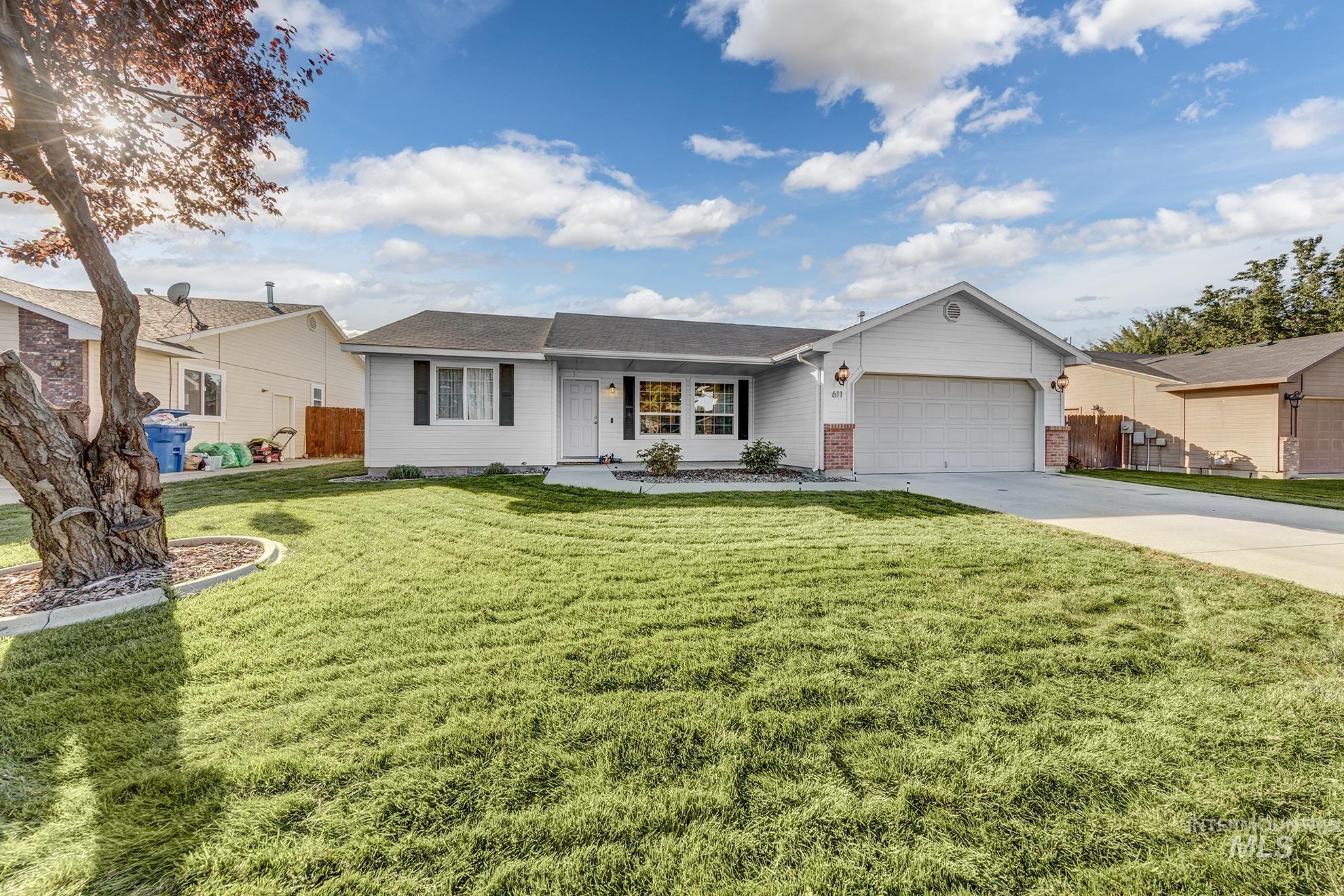Ranch-style house featuring concrete driveway, a garage, a shingled roof, and brick siding