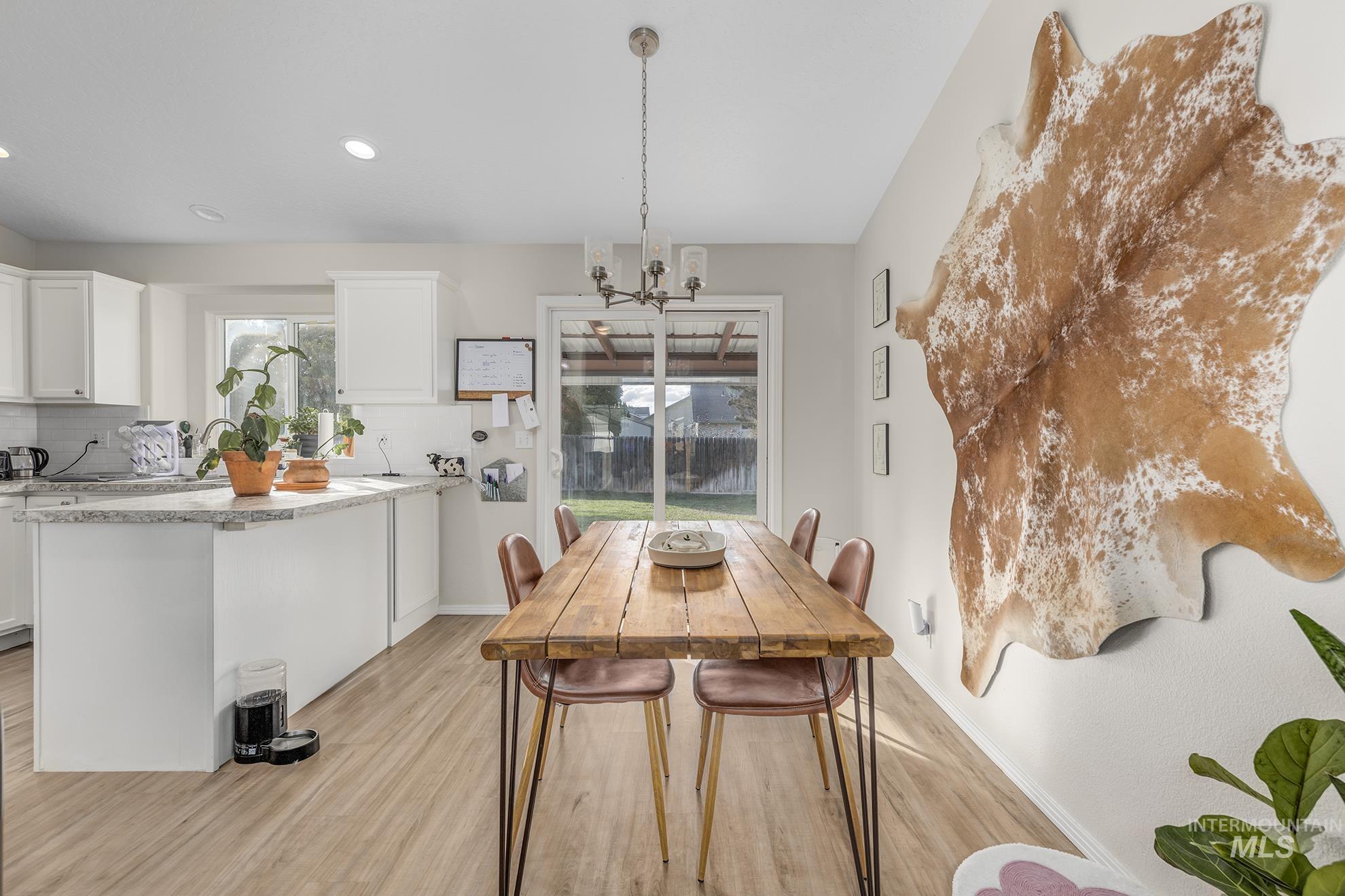 Dining area featuring a chandelier, light wood finished floors, and recessed lighting